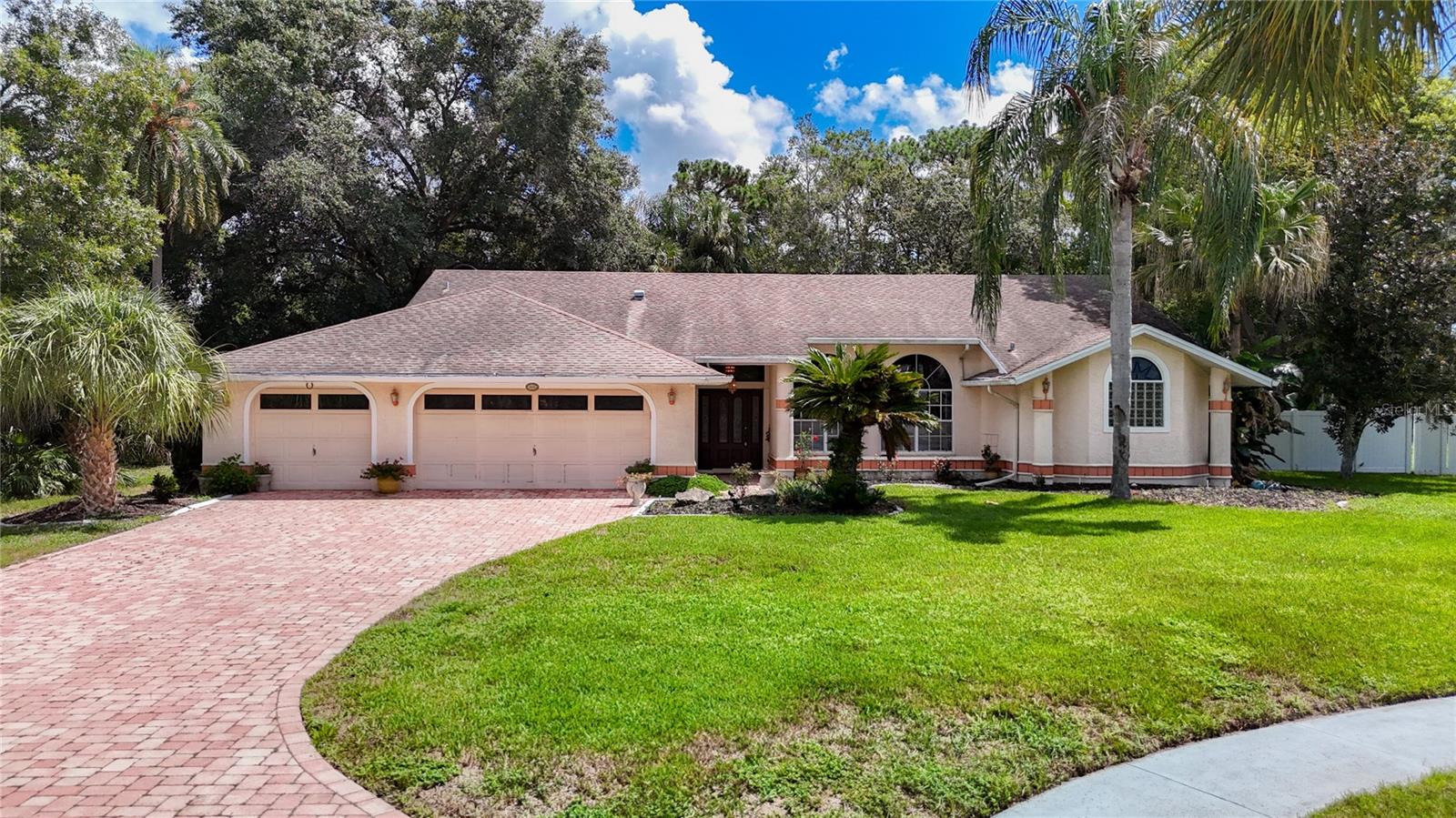 BRAND-NEW roof coming prior to closing. Come envision the endless possibilities with this 3 bedroom, 2 ½ baths, 3 car garage pool home on almost 1 acre. Located at the end of a cul-de-sac and in the desirable Autumn Oaks Community. Step inside and discover a home ready to be transformed with your personal touch. The expansive open floor plan features the living and dining areas that flow effortlessly, creating a welcoming environment for gatherings both large and small. A separate family room with a fireplace just off the spacious eat-in kitchen, which is equipped with granite counters, stainless steel appliances, a walk-in pantry, a dry bar and an extended counters which are perfect for meal prepping and/or entertaining. The primary suite boasts an ensuite bathroom complete with a jacuzzi tub, a separate walk-in shower, dual sink, double walk-in closets, sliders to the lanai and cathedral ceilings. The home features a well-appointed second and third bedroom, both featuring walk-in closets and share the pool bath. One of the standout features of the property is the recently resurfaced pool with dolphin inlays, promising endless hours of relaxation and fun beneath the Florida sun. The pool area is complemented by a sprawling lanai with an extended covered section—ideal for outdoor dining, lounging, or simply enjoying the view. A portion of the covered lanai is a showstopper, featuring rich cedar ceilings, striking stone accent walls, and a stylish dry bar. Host unforgettable gatherings around the huge, free-standing hot tub or serve cocktails from the bar as friends and family unwind in this private retreat. While this remarkable home is move-in ready, it offers the perfect canvas for updates to suit your unique style. Whether you dream of gourmet kitchen upgrades, modern bathroom finishes, or a lush backyard oasis, the possibilities are truly endless. Other amazing features include an extended paver driveway and walkway, and a new AC. Walking distance to the park, playground with tennis and basketball courts. LOW HOA FEE & NO CDD FEES OR FLOOD INSURANCE REQUIRED! Lots of shopping and favorite local dining options nearby. Minutes from the famous Weeki Wachee live mermaids, Pine Island Park and Roger’s Park for fun on the water. Close US 19 & to the Suncoast parkway for quick access to the airport, Tampa, Clearwater and St. Pete Beaches (Ranked in the top 5 Beaches in the US), also close to the famous Tarpon Springs Sponge Docks. Enjoy everything Tampa Bay has to offer from the new Downtown Riverwalk, TOP US BEACHES, boating, fishing, golfing, cultural entertainment, and museums...and of course beautiful year-round weather!