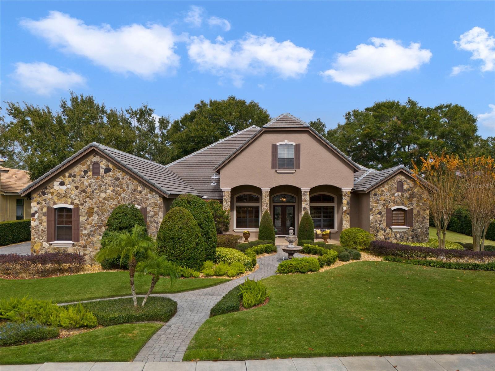 Welcome to this exquisite five-bedroom, four-bath residence, in one of the most desired and prestigious areas of Sorrento. Surrounded by lush landscaping and towering mature trees, the streets of this serene enclave offer a picturesque setting that reflects the charm and exclusivity of the area. This meticulously maintained home is a testament to luxury and sophistication, with every imaginable upgrade thoughtfully incorporated throughout. A recent roof inspection ensures peace of mind, while the comprehensive list of enhancements, available upon request, further highlights the exceptional attention to detail. Upon entering, you are greeted by a grand office, ideal for quiet reflection or remote work, and a formal dining area for hosting memorable gatherings. A stately sitting area offers an elegant space for relaxation. The expansive primary bedroom, conveniently on the main level, provides a serene retreat with views of the private, meticulously landscaped grounds. The primary bath suite is designed for luxury, privacy and relaxation. The heart of the home is the stunning open-concept kitchen, featuring a Wolf induction cooktop, higher-end kitchen appliances, solid wood cabinetry and an inviting eat-in breakfast area. A cozy coffee and wine nook adjoins the kitchen. The spacious downstairs family room, with its expansive sliding glass doors, seamlessly flows to the outdoor oasis, where the impressive backyard awaits. Enjoy year-round outdoor living with a sparkling pool, spa, fully equipped outdoor kitchen and ample space for entertaining, all enveloped in the privacy of mature trees and a fully fenced yard. The thoughtfully designed floor plan includes two Jack and Jill bedrooms on the main level, offering comfort and convenience for family or guests. Upstairs, you'll find a versatile space that can function as a second family room. The massive bedroom upstairs features an expansive deck that overlooks the serene backyard, while an additional large bonus room with a full bar, offers endless possibilities as a media room, guest suite or hobby space. With completion of the nearby SR 429 expressway, commuting to the city is now a breeze, ensuring a quick and stress-free drive to work or entertainment options. Residents of this community enjoy a host of exclusive amenities, including a clubhouse, fitness center, tennis courts and a pool. This home offers the ideal blend of luxury, comfort and convenience in one of the area's most sought-after locations. Come experience the epitome of refined living and schedule your private showing today!