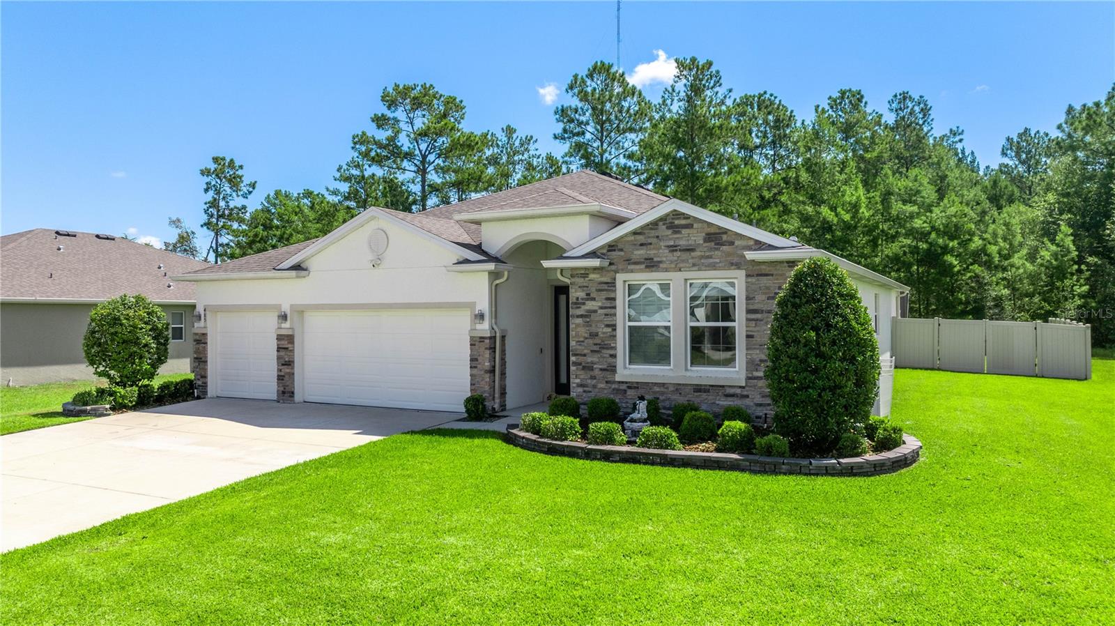 Stunning home located in the highly sought after SE Ocala! This 2368 square foot, 4/3 was constructed in 2023. The massive great room which opens to the kitchen greets you as you walk in this inviting home. New Luxury Vinyl Plank floors were installed last year in all the main living areas for a beautiful and rich look. The huge kitchen has granite counters, a large island, walk in pantry, 42" white shaker cabinets and stainless steel appliances including a new refrigerator. There are 2 bedrooms in the front of the home share a bathroom and an additional guest room in the back of the home has an en suite bath. All bedrooms have brand new, updated carpet. The interior of the home was also painted with upgraded paint in 2023 for a gorgeous appeal. Outside, an $80,000 salt water POOL with HOT TUB and screen was installed in 2023. It is heated and has LED lights and has a gorgeous view of the woods behind it. The yard is also fully fenced for your furry friends. This home is truly an oasis and will be the envy of all your friends!