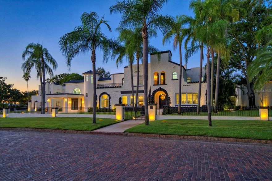 Set within the prestigious Pasadena corridor and adjoining the historic Jungle Prada district, 320 Park St. is one of St. Petersburg’s most distinguished estates. Long known as the “Faith Mansion,” this gated property—once a sought-after setting for weddings and elegant events—has been transformed into a refined modern residence where timeless architecture meets effortless contemporary luxury.

A sweeping circular drive and porte-cochère lead into a striking 23-foot entrance hall crafted in high-polished black-and-white marble, illuminated by impact-rated Pella windows. It’s graphic, elevated, and instantly memorable—an editorial-quality backdrop that feels both classic and current.

Beyond the foyer, the grand ballroom unfolds with coffered beams, plaster walls, and two sparkling crystal chandeliers. Designed for large gatherings yet equally suited to quiet evenings, the space balances drama with serene, livable elegance.

The estate offers two beautifully planned kitchens. The west-wing chef’s kitchen features a sculptural custom range hood, commercial Z-Line gas range (in both kitchens), dual pantries, wine refrigerator, and a substantial island with a sleek passthrough to the dining hall. A separate banquet kitchen supports hosting at any scale with ease.

The primary suite is a tranquil retreat with plantation shutters, a sitting area, dual walk-in closets, and a morning bar. Its marble-wrapped bath includes double vanities, a soaking tub, and a remarkable 140 sq. ft. walk-in shower with multiple showerheads. A lofted lounge overlooks the foyer and ballroom with architectural presence.

The entertainment wing includes tin ceilings, a custom copper penny–topped bar, a wine cellar, and a private 8-seat theatre with a 115” retractable screen, Optoma projection, surround sound, and reclining leather seating. Every bedroom is ensuite.

Behind the scenes, the home has been comprehensively modernized: new roofs, seven HVAC zones many with dehumidifiers, full electrical rewiring, new irrigation and landscape lighting, new pool pump, Generac generator, impact windows, and dual hot water systems—all contributing to comfort and peace of mind.

Outdoors, the PebbleTec pool and redesigned terraces offer multiple areas for dining and lounging. The outdoor kitchen includes a gas grill, Big Green Egg, sink, and generous prep space. The grounds feature Zoysia grass, irrigated raised garden beds, and fruiting trees including mango, Meyer lemon, fig, avocado, Asian pear, and lime.

Connected via a covered breezeway, the property’s flexible auxiliary spaces include a 1,200+ sq. ft. garage structure with epoxy floors, industrial-grade doors, gym area, separate golf cart garage, and an attached 1-bedroom, 1-bath apartment with kitchenette—ideal for an au pair, guests, multigenerational living, or a private office/studio.

Lighted walkways, pedestrian gates, and two drive-in gates enhance the estate’s sense of arrival. With downtown St. Petersburg, Treasure Island, and the Gulf beaches only minutes away, this estate delivers elegance, ease, and architectural poise.

A home of scale, beauty, and impeccable composition, 320 Park St. invites you to live each day with the elevated style of a magazine-worthy estate.