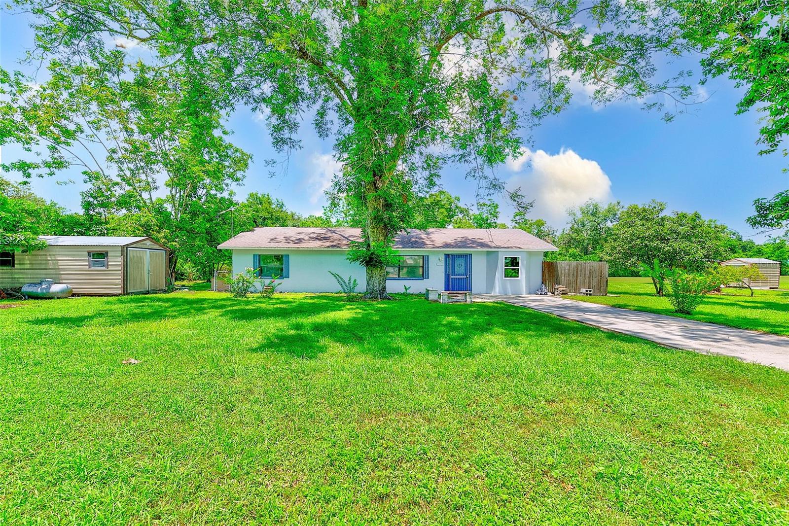 One or more photo(s) has been virtually staged. Nestled on 1 acre in Zephyrhills, this inviting residence blends Florida-style country living with modern comforts—all without HOA constraints. Perfect for anyone craving space, privacy, and freedom to expand. Country-living serenity just minutes from Downtown Zephyrhills. This move in ready home feature a large kitchen, family room for large gatherings, and inside laundry. Several out buildings for all your hobbies.
Exterior & Utilities: Concrete-block structure with asphalt roof, private well water, septic system, and no municipal utility dependencies.
Site & Surroundings: Flat, fenced 1-acre lot allows room for gardening, outdoor recreation, or potential storage structures. Mature trees provide shade. Property is zoned AR for single-family living. Book your appointment before this one is gone.