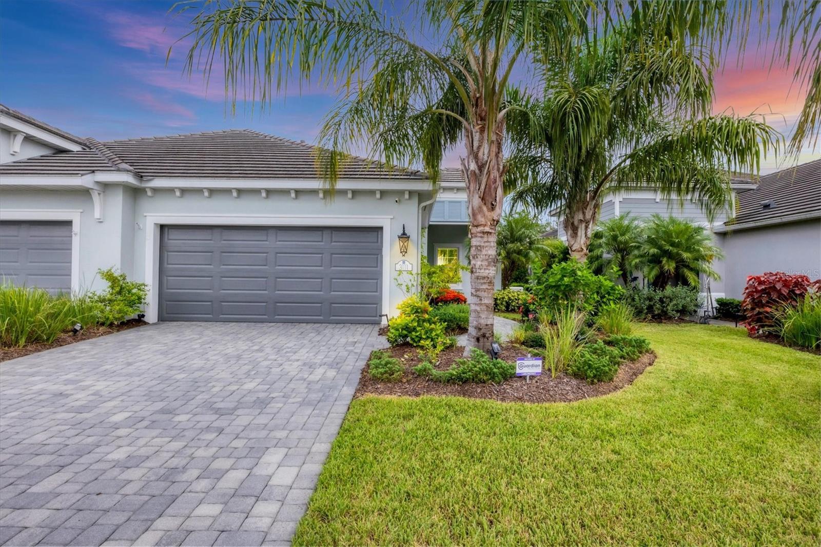Welcome to this move-in ready ''Tidewinds'' villa in the award winning gated community of Indigo! This meticulously cared for villa is built strong and safe with its WHOLE HOME STANDBY ''Generac'' generator, cinder block construction, concrete tile roof, HURRICANE protection for all energy efficiency windows, whole home surge protector AND is located in the desirable "X'' floodzone. This ''Smart Home'' not only enables you to lock/unlock the front door, adjust the thermostat and open/close your garage door all remotely but has a ''Guardian'' security system plus professional surveillance cameras for peace of mind. Your new villa boasts 2 bedrooms, 2 full baths, a dedicated den, great room, dining room, kitchen with breakfast bar, indoor laundry room with TWO storage closets in the laundry and covered extended screened in lanai! Throughout the villa you will find 5 1/4" deco baseboards, ceramic tile flooring, crown molding, multiple trey ceilings, 16-seer rated TRANE HVAC unit with upgraded UV light air filtration, full gutter system and freshly sealed pavers! The study/den offers versatile room for either an office space, play room and or additional room for guests provided the built-in has a hidden Murphy bed. The kitchen boasts a nice sized pantry, LED undermount lighting to complement the high level granite countertops, upgraded back-splash, 5-burner natural gas range, stainless steel appliances, Island with breakfast bar and LED recessed lighting. The master bedroom includes a LARGE walk-in closet plus an additional built-in closet, separate dual vanities and a walk-in shower with upgraded porcelain tile. The great room with its expansive tray ceiling showcases a spacious environment with more than enough room to entertain guests. Open the three paneled sliders to your new paver rich private screened and covered lanai with custom sunshade. With an eastern facing sunrise, this is the perfect location to enjoy your morning coffee. Your new garage comes equipped with a HURRICANE IMPACT garage door, 240V socket for electric vehicle charging, heavy duty metal overhead storage racks and a steel garage attic ladder. Indigo is an active community that features a full time on-site manager as well as a full time activities director that manages an extensive calendar of activities for all ages. A-Rated Gullett Elementary AND Mona Jain Middle School are right outside our gates too! You can also expect sidewalks on both sides of the street, ''Oasis'' pool/spa, resort style heated community pool/spa at the main clubhouse where you will find 5 cabanas with an abundance of seating, 4 pickleball courts, 2 bocce ball courts, 24-hour exercise gym, meeting room/banquet room and playground. Indigo is not only a community that takes care of all ground maintenance to include mowing, fertilizing, irrigation, shrubs and mulch but is right around the corner to a plethora of dining, banking, entertainment, public transportation and MORE!