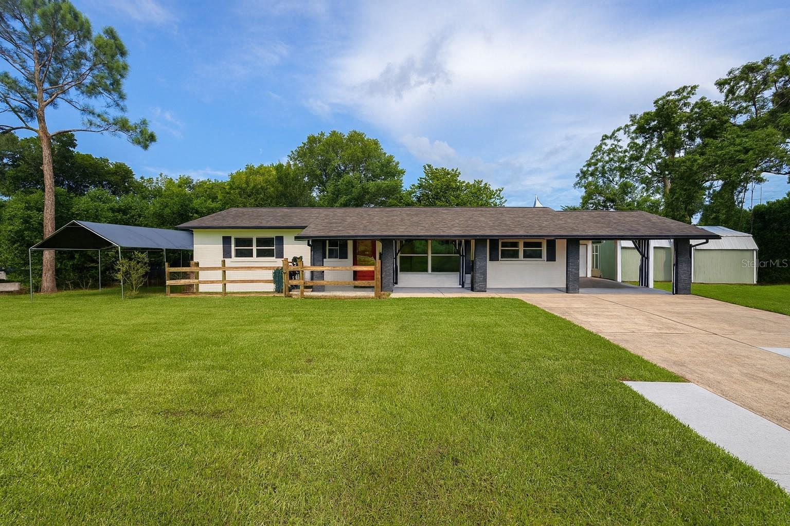 This charming two-bedroom, two-bathroom ranch-style home near East Crooked Lake in Eustis is designed for comfortable and easy living. Set back from the road with a long, newly widened driveway, the property offers both privacy and convenience. The fully enclosed yard provides a secure space for children or pets to play, while the screened-in lanai creates a peaceful retreat for morning coffee or evening relaxation.
Inside, the home features a fully remodeled kitchen with granite countertops, a newly added island, and appliances less than three years old. Laminate flooring runs throughout, and neutral paint colors create a fresh and welcoming ambiance. The master bedroom includes a built-in closet and private en-suite bath, which has been updated, along with the guest bathroom, with a tiled shower, rainhead fixture, and modern finishes. A versatile bonus room located just off the kitchen can serve as a home office, guest bedroom, or flex space, and the adjacent laundry room adds to the home’s practicality.
The property offers excellent outdoor amenities including a covered carport with side entry, a covered pavilion with rear access designed specifically to shelter a boat, and multiple storage sheds for tools and equipment. Pet enthusiasts will appreciate the unique kennel space with power, water, and drainage providing additional flexibility, easily convertible into a greenhouse or workshop.
With its convenient location close to downtown Eustis and Mount Dora, this home combines charm, function, and lifestyle appeal. The sellers are willing to include the camper and 5th Wheel if desired, making this a versatile and move-in ready property with endless possibilities.