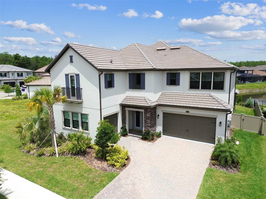 Built in 2023 with over a dozen premium upgrades, this 5BR/4BA home sits on an oversized corner lot in the gated enclave of Ravello at Estancia. Designed for effortless indoor-outdoor living, it features stone accents, upgraded landscaping, a brick paver driveway, and a 3-car garage with epoxy floors and EV hookup.

Enjoy a stunning entrance as you step inside, where an exquisite wrought iron staircase makes a dramatic and elegant first impression. The flexible floor plan includes a private office/den, formal dining room, bonus flex room, and a gourmet kitchen with farmhouse sink, pendant lighting, butler’s pantry/beverage bar, and café-style dining. Pocket sliding glass doors glide open to create a wide, unobstructed opening, allowing for a continuous flow between indoor and outdoor spaces—perfect for seamless entertaining and effortless indoor-outdoor living. The upstairs owner’s suite offers a private screened in wrought iron balcony, oversized walk-in closet, soaking tub, frameless glass shower, and dual quartz vanities.

Upgrades include 3M heat-reducing window film, wrought iron stair railings, outdoor kitchen hookups (gas/plumbing/electric), garage water treatment hookup, fresh 2025 interior paint, and hurricane shutters. Two large, screened lanais and a fully fenced back and side yard provide space for a future pool while also maintaining a grassy play area.

Located in Estancia with resort-style amenities, a luxury clubhouse, zero-entry heated pool with slide and lap lanes, tennis, pickleball, basketball, parks, and trails just minutes to shopping, dining, I-75, Tampa, and Tampa International Airport.