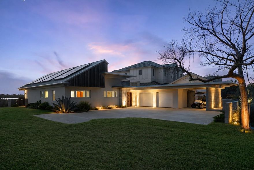 Quietly tucked away on sought-after N. Indian River Road, set apart from the bustle of Peninsula Avenue and positioned directly on the Intracoastal Waterway in the heart of New Smyrna Beach, this extraordinary custom residence is a rare fusion of architectural artistry, modern technology, and effortless coastal luxury. Completely reimagined by renowned local architect Kevin Schweizer and crafted by respected builder Don Smith, every detail of this home was intentionally designed to blur the line between indoor and outdoor living while embracing the surrounding waterfront lifestyle. Just moments by boat to Ponce Inlet and the Atlantic Ocean, and only blocks from the unmatched white sand beaches of New Smyrna Beach, the property offers one of the area’s most coveted locations for both boating enthusiasts and beach lovers alike. Inside, rich French oak wood flooring intertwines seamlessly with concrete and tile surfaces, flowing naturally throughout the home and extending outdoors to create a cohesive architectural experience. Artistic details are found at every turn, including restored original redwood reclaimed from the previous residence and thoughtfully incorporated into custom woodwork throughout the home. The gourmet kitchen is anchored by stunning mahogany cabinetry and outfitted with premium appliances including Liebherr refrigeration and Thermador cooking appliances. Designed for both elevated entertaining and everyday comfort, the outdoor living spaces rival a private resort. The custom pool and spa by All Aqua Pools feature a sun shelf, integrated spa, Pentair automation system, and a dramatic sunken natural gas fire pit that creates an unforgettable waterfront ambiance. Technology and efficiency were equally prioritized throughout the home. A fully integrated Vantage smart lighting system, whole-home audio/visual controls via iPad, surround sound, patio and poolside speakers, whole-house vacuum system, security cameras, leak detection with automated water shutoff, and whole-home solar power combine to deliver exceptional convenience with remarkably low utility costs. Additional luxury features include natural gas service, smart home automation, extensive security systems, Napoleon outdoor grill, wine cooler, whole-home audio, and customized lighting scenes that allow the home to adapt effortlessly to any mood or occasion. This is more than a waterfront home — it is a one-of-a-kind coastal retreat where architecture, craftsmanship, technology, and lifestyle come together in perfect harmony on one of New Smyrna Beach’s most desirable stretches of Intracoastal frontage.