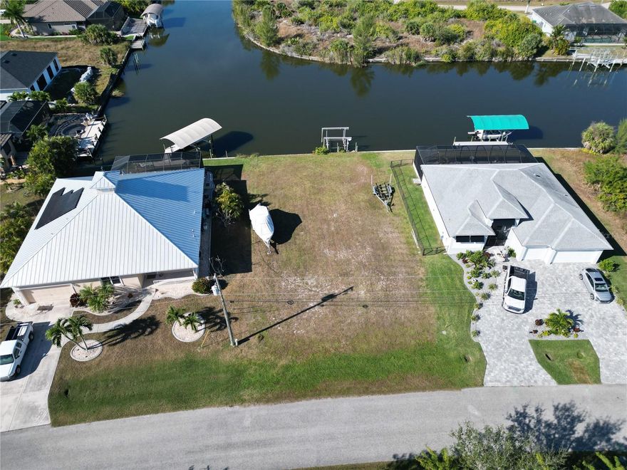 Sailboat Capable Waterfront Lot with 83 feet of concrete seawall in place with direct access to the Charlotte Harbor and Gulf of Mexico.
All utilities are in place making this a Prime Location to Build your new home.  The property is cleared and is 76 x 83 feet in size.  There is a lift on the water for your boat as well.  Currently there is no power to the lift, so we don't know if it's operable or not. There is a nice sized water basin behind the property giving you ample room to navigate your boat.  The rear of the property faces West giving you beautiful sunsets over the Acquarius Waterway.  The property is roughly 20 minutes to the beaches on Boca Grande Island or Manasota Key, 15 minutes to shopping / dinning and 10 minutes away from several golf courses.  The Community offers over 50 miles of navigable waterways, multiple parks, play, sidewalks and a boat ramp.  Buy as an investment or build your new home; either way Secure Your Piece of Paradise Today.