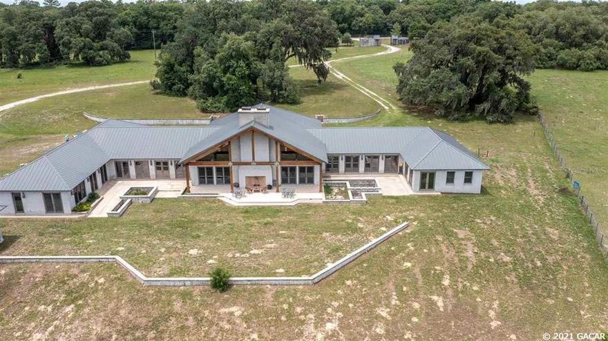 This spectacular 144-acre hilltop farm offers fantastic views high above Levy's Prairie and a resort-style feel. From the gated entrance follow the trail with wonderful views in every direction to the main entrance of this one-of-a-kind custom-built 7,200-square-foot home. Upon entering the home you are immediately struck by the amazing details of the grand entry with its huge cut glass doors, marble floors, and intricate wood details, from there you enter the huge family area with towering wood beam carved ceiling, walk-in fireplace, and views of the prairie below. The kitchen has a large island with lots of room that flows into the family area. The primary bedroom offers a large walk-in closet, sitting area, walk-in shower, and garden tub. There is an oversized four-car garage, a detached sauna/workout building, stables, and a barn. This is an incredible opportunity at a great price!