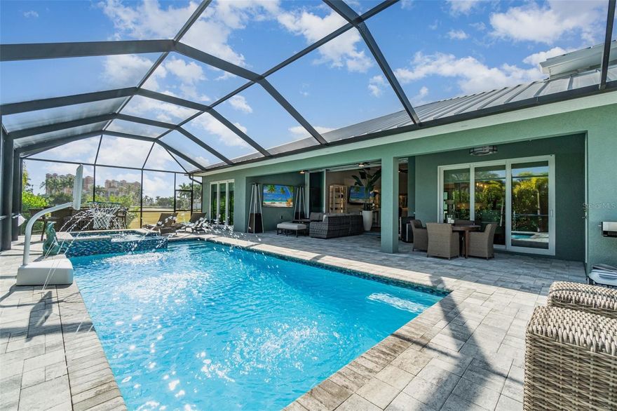 Luxury living takes on new meaning in this remarkable Southwest Cape Coral property, where architectural intention, exceptional garage capacity, and resort-style outdoor living come together to create a home designed around lifestyle. Built for those who value craftsmanship, versatility, and space to pursue their passions, this residence stands apart for both function and refinement.
Located in the heart of SW Cape Coral, the property features an impressive 50-ft deep and 25–29-ft wide custom RV garage capable of accommodating up to six vehicles, along with a separate two-car garage. The RV bay is accessed through an oversized 14-ft high by 16-ft wide door, providing ample clearance for Class A motorhomes, trailers, lifted trucks, or specialty vehicles. Generous interior height allows for the possibility of installing a vehicle lift system, creating stacked parking and even greater storage capacity for collectors or hobbyists. Just beyond the garage, a 37-ft custom paver extension provides additional room for boats, jet skis, trailers, or a dedicated project space.
Inside, a thoughtfully designed split floor plan offers both openness and privacy. High ceilings, tray details, custom window treatments, and elevated finishes create a cohesive interior. The open-concept kitchen features premium cabinetry, upgraded appliances, and a spacious center island with seating while overlooking a bright great room enhanced with built-ins—an ideal setting for entertaining guests or daily living.
The primary suite serves as a private retreat, complete with a spa-inspired bath, oversized walk-in shower, and an expansive open closet designed for comfort and practicality. Guest accommodations are thoughtfully positioned to maximize privacy, making the layout well suited for visiting family, seasonal residents, or rental possibilities.Outdoor living shines with a heated saltwater pool and spa set within an expansive paver lanai. Tropical landscaping surrounds the space, enhancing privacy and creating a serene setting perfect for gatherings or relaxing during peaceful Florida evenings.
Designed with efficiency and convenience in mind, the home includes spray-foam insulation for improved energy performance, an instant hot-water recirculating system for added comfort, and smart home integration throughout. A monitored security system with motion, door, and window sensors offers peace of mind. Bluetooth-enabled irrigation, high-speed mesh Wi-Fi across the property, accessible attic storage, and multiple mini-split climate systems—including in the RV garage, primary suite, and guest bedroom—ensure year-round comfort and control.Constructed with concrete block, a durable metal roof, and impact-resistant windows and doors, the home is built for durability and storm resilience. The oversized lot provides paved parking, privacy, and flexibility for vehicles, golf carts, and recreational equipment without HOA restrictions. Portions of the home, including the primary suite and RV garage, can also be secured independently from guest-accessible areas, offering added flexibility for part-time residency or rental opportunities.Conveniently located just minutes from waterfront dining, marinas, pickleball courts, parks, walking trails, and vibrant entertainment, this property embodies the Southwest Florida lifestyle. More than a residence, it is a purpose-built environment designed to support how you live, store, entertain, and enjoy every season in comfort and style.