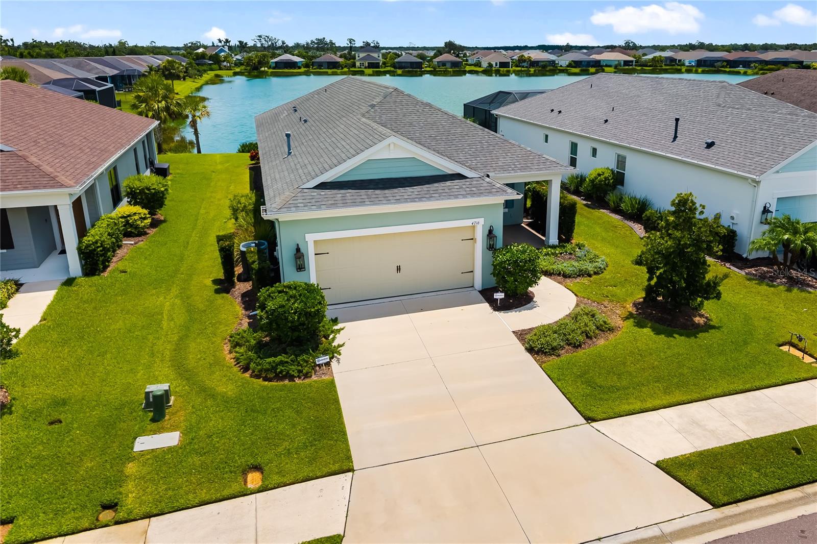 Welcome to your dream waterfront home in the highly sought-after community of Canoe Creek! This stunning 3 bedroom home, complete with a private office/den, offers a perfect blend of style and comfort. Step inside to an open, light-filled floor plan featuring tile floors throughout the main living areas and expansive water views that set the tone for relaxation. The upscale kitchen is designed for both cooking and entertaining, with a large center island, granite counters, stainless appliances, and a seamless connection to the living room—perfect for hosting friends and family. The oversized primary suite is a true sanctuary, showcasing tranquil water views, dual sinks, a walk-in tile shower, and a spacious walk-in closet. Two additional bedrooms are located at the front of the home, each with its own walk-in closet and easy access to a full bathroom. Step outside through sliding glass doors to your private screened lanai and extended custom stamped-concrete patio. This outdoor oasis is ideal for dining, lounging in the sunshine, or simply taking in the breathtaking distant lake views. Few more features include oversized two-car garage with extra storage space, epoxy flooring on front and rear patios, electronic roller shades, and much more. Canoe Creek has a resort-style pool, clubhouse, fitness center, dog park, tennis & pickleball courts, and a vibrant community spirit, all with low HOA fees. Perfectly situated near I-75, shopping, dining, and just minutes from Parrish, Lakewood Ranch, and beyond, this home offers both convenience and an incredible lifestyle. Schedule your private showing today and start living the waterfront life you’ve always dreamed of!