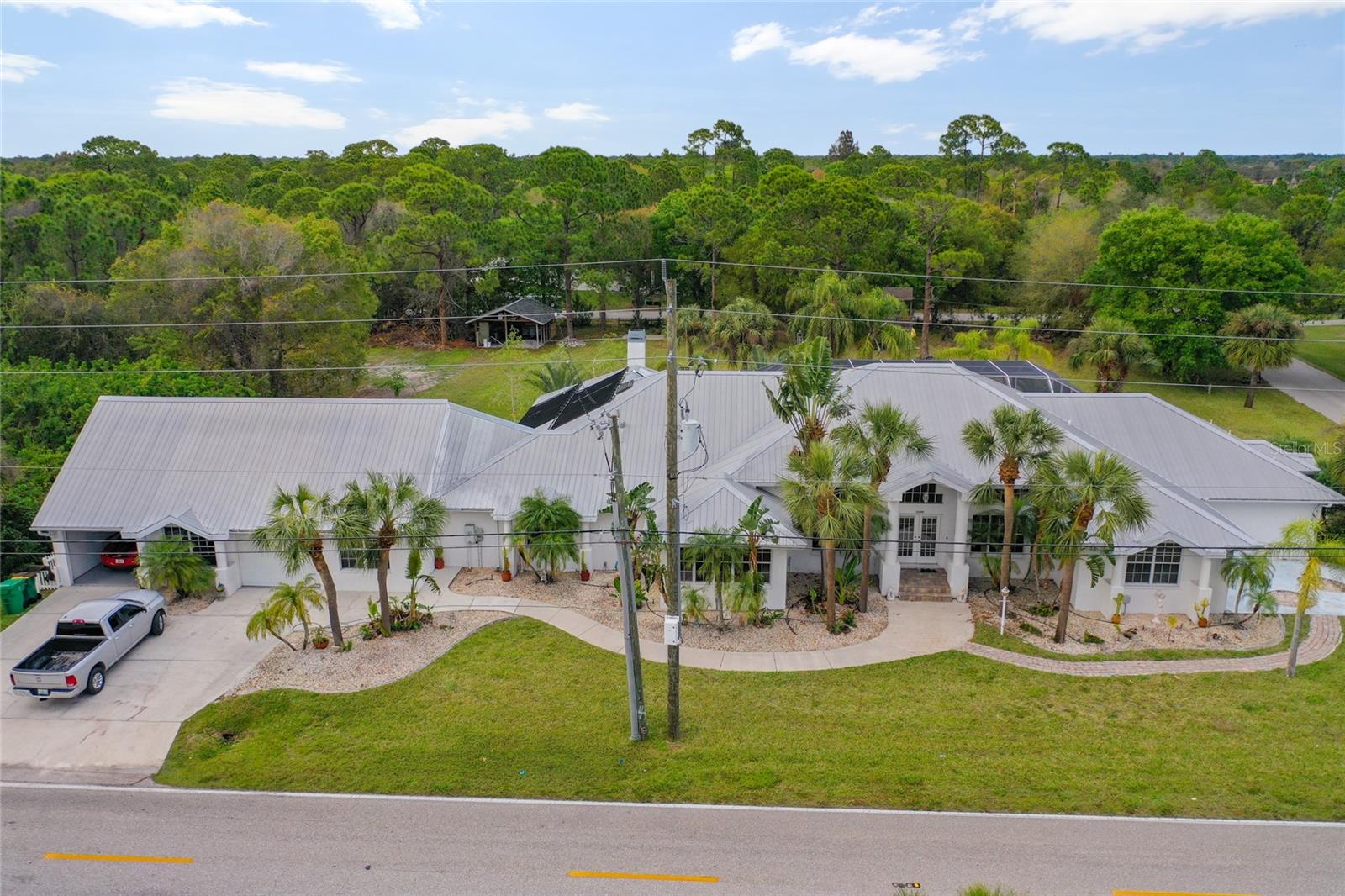 The stuff that dreams are made of. Stunning, 5 bedroom, 3 bathroom, custom built,
multi-generational pool home with potential mother-in-law suite(s). The perfect home for
large families, with room for an RV, boats, toy storage, and no deed restrictions. This
palatial home sits on 4 lots - more than 1 acre total - complete with separate covered
outdoor cooking area, storage shed, ample parking, play area for the kids, and enough
yard for a football game. As you enter the home, you are greeted with a formal living
room, perfect for entertaining, with sliding doors to the pool area. A formal dining room
sits off the spacious kitchen, with an additional full-size media/family room on the
opposite side, also overlooking the pool. Home features a 3 car garage, eye-catching
ceramic tile throughout the house, a garden room with skylight, spacious game
room/man cave featuring an inviting bar area, cozy upstairs loft, and a wood burning
fireplace. Kitchen offers an oversize pantry and gas stove, while the master bedroom
features a sitting area, 2 roomy closets, oversized glass block shower, granite
countertops, his and hers sinks, and garden jacuzzi tub. Oversized pool deck with pool
bathroom and multiple access points provides yet another ideal setting for time with
guests. Metal roof features newly-installed energy-saving solar panels. Potential to
subdivide or build accessory dwelling. Convenient access to Interstate 75 and nearby
golf and boating in Punta Gorda, as well as shopping and dining in Port Charlotte.
Schedule an appointment to experience this special home today!