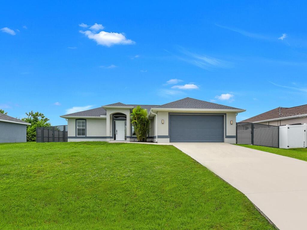Discover this inviting 3-bedroom, 2-bath home offering the perfect blend of comfort, style, and convenience in one of Cape Coral’s growing neighborhoods. Built in 2003 and thoughtfully maintained, this residence features a bright, open-concept layout with a spacious great room design and vaulted ceilings that create an airy, welcoming feel. Large windows invite abundant natural light throughout, while the southern rear exposure provides the perfect backdrop for adding a future pool or enjoying sunny afternoons on the extended lanai and patio area. The kitchen is as functional as it is stylish, with white cabinetry, stainless steel appliances, and plenty of counter space to make cooking and entertaining a breeze. The primary suite offers a peaceful retreat with a large walk-in closet, dual sinks, and a walk-in shower, while two additional bedrooms and a full guest bath provide flexibility for family, guests, or a home office. Recent updates include fresh interior and exterior paint, giving the home a crisp, modern look. The fully fenced backyard features a sleek, modern privacy fence and ample space for outdoor living, gardening, or play. Additional highlights include a two-car garage, manual storm shutters for peace of mind, and no assessments. The property is not located in a designated flood hazard area, so no flood insurance will be required. This home combines low-maintenance living with modern updates and a prime location near schools, parks, shopping, and dining, making it a wonderful opportunity to enjoy the Cape Coral lifestyle.