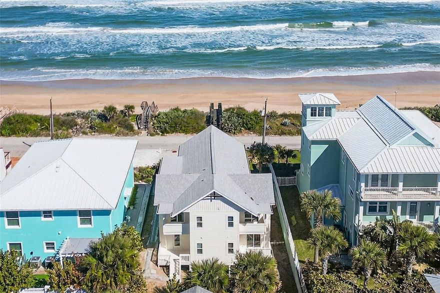 Located in the highly desirable Bethune Beach community, just south of New Smyrna Beach, 6118 South Atlantic Avenue offers a rare opportunity to own a refined coastal residence with panoramic Atlantic Ocean views, private beach access across the street, and a lifestyle defined by privacy, nature, and elevated design.

The home enjoys a premier setting along a non-driving section of the beach, providing a quieter shoreline experience. From the front of the property, residents enjoy unobstructed ocean views and direct beach access via a private walkover just steps away, while remaining close to dining, shopping, and cultural attractions in New Smyrna Beach.

The residence has been thoughtfully updated to maximize livable space, with approximately 1,300 square feet of previously non-living area renovated and incorporated into the home. A basement area currently in progress (approx. 462 sq ft) offers potential for future build-out or additional usable space.

Inside, the home presents a bright coastal-modern interior highlighted by white shiplap walls, wide-plank hardwood flooring, and vaulted ceilings with dark exposed beams. The open-concept living area is filled with natural light and flows seamlessly between living, dining, and outdoor spaces. Large sliding glass doors open to a private balcony, inviting ocean breezes and extending the living space outdoors.

The kitchen features rich dark cabinetry, sleek white countertops, and a whitewashed brick-style backsplash, along with a full stainless-steel appliance package including a gas range with vent hood, wall oven, built-in microwave, dishwasher, and refrigerator. A brushed-gold spring faucet adds a subtle luxury touch.

Bathrooms showcase spa-inspired finishes with large-format black marble-look tile, matte black fixtures, and modern lighting. Bedrooms continue the light, airy feel with white plank ceilings, recessed lighting, and direct balcony access. Storage is enhanced by a custom walk-in closet system.

The oversized garage includes a clean epoxy-finished floor, offering ample space for parking, storage, or beach and water-sport gear.

Just minutes away, **Mosquito Lagoon—part of the Indian River Lagoon system—**offers world-class kayaking, paddleboarding, fishing, and wildlife viewing. The area also provides the unique opportunity to view rocket launches from Cape Canaveral during scheduled launches.

This property combines ocean views, private beach access, refined living space, and proximity to Florida’s most prized natural waterways, making it an exceptional coastal offering.