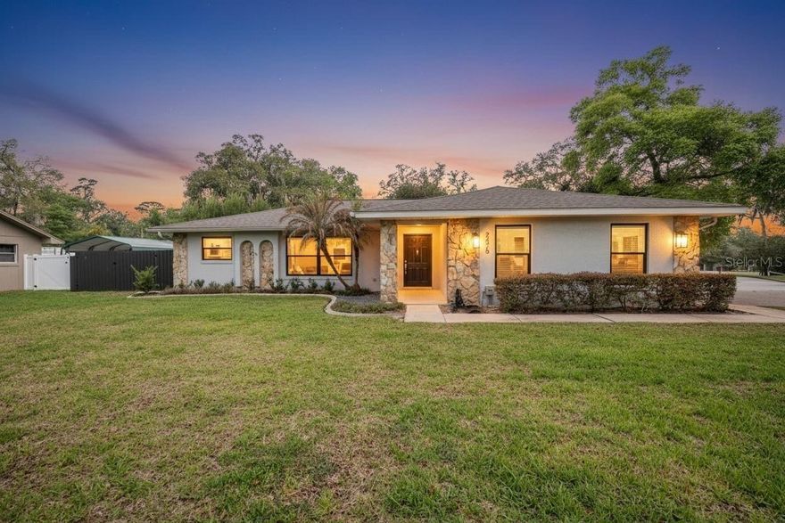 Beautiful completely renovated and move-in ready 3BR/2BA split-plan home situated on a corner lot with extra parking and a private backyard. The home features tile and luxury vinyl flooring throughout and an open living area that can easily accommodate multiple seating or dining spaces. A pretty stone wood-burning fireplace (never used) creates a cozy focal point, and the enclosed Florida room with its own wall AC provides an additional living space overlooking the backyard.

The updated kitchen features stainless steel appliances, dark granite countertops, white custom cabinetry, and a breakfast bar. The spacious primary suite offers a beautifully renovated bath with a free standing soaking tub, separate shower, double sinks, high-tech toilet, and walk-in closet.

Bedrooms 2 and 3 feature luxury vinyl plank flooring, and the guest bath has also been tastefully renovated with granite and updated fixtures.

Step outside to enjoy the private backyard with a large side gate allowing space to pull in a boat or RV behind the privacy fence, plus a clean utility building ideal for storage or a workshop. The driveway also includes an extra concrete pad for additional parking.

Additional highlights include a side-entry garage with attic stairs and access door to the driveway, well for irrigation, new windows, new plumbing, and fresh exterior paint within the last 2–3 years. Roof replaced in 2022 and AC in 2020.

This beautifully updated home offers modern finishes, flexible living spaces, and plenty of room for parking, storage, and outdoor enjoyment.
