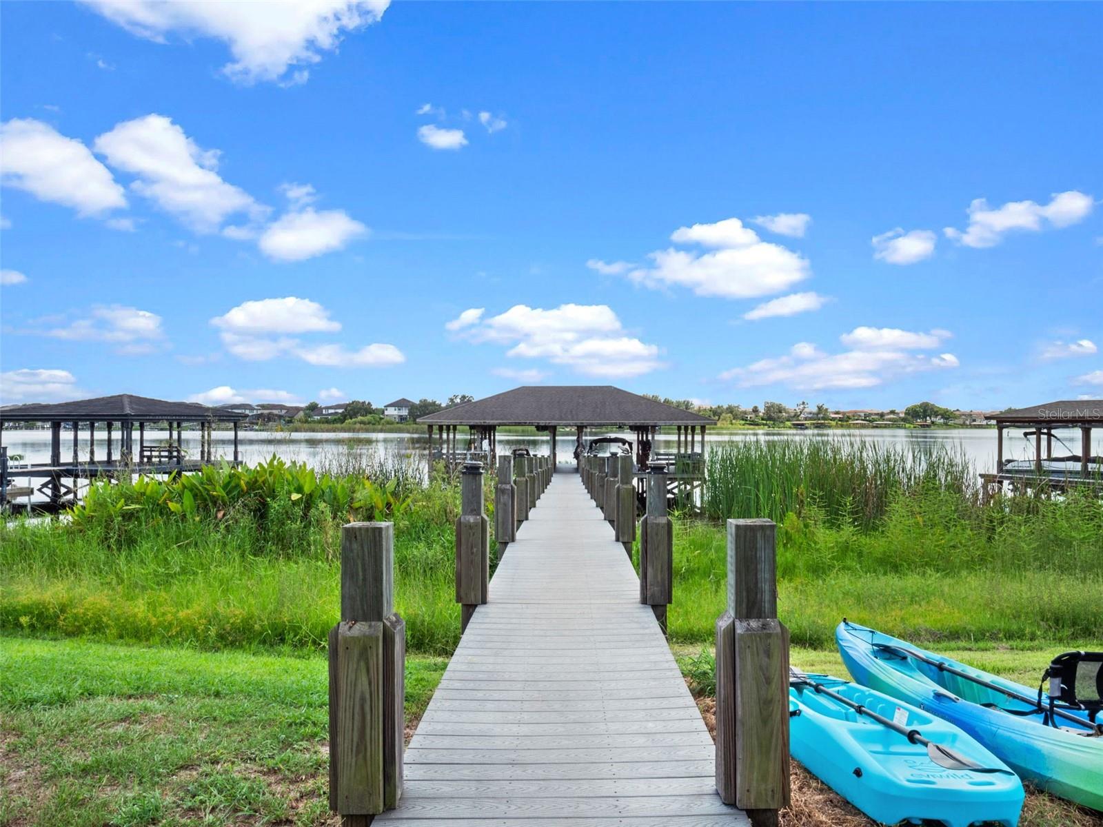 Presenting 16086 Johns Lake Overlook Drive – Lakefront Elegance in Hickory Hammock – $1,850,000
Wake up to sweeping views of Johns Lake and end your day with brilliant sunsets from your own backyard. Set on a half-acre with 100 feet of lake frontage, this 5-bedroom, 4 full/2 half-bath home offers 4,474 sq ft of living space, a private dock with boat lift, and a resort-style pool combining refined finishes with functional design for both everyday comfort and entertaining.
A dramatic two-story foyer with soaring ceilings sets the stage, flowing into an expansive open layout centered around a chef’s kitchen. This culinary showpiece boasts two oversized wood-wrapped islands, lustrous quartz countertops, white cabinetry with custom storage, convection oven/microwave combo, an electric cooktop, and a walk-in pantry. The adjoining dinette and spacious family room seamlessly connect through triple sliders to the screened lanai, creating an effortless indoor-outdoor living experience.
Outdoors, enjoy a heated saltwater pool with lap lane, sun shelf, and lighting, all framed by beautiful landscaping and a fully fenced yard. On the shores of John's Lake, your dock features a 7,500-lb lift and Trex decking for durability and functionality. Also equipped with a dedicated seating area, electric and water, this space creates a versatile outdoor retreat—perfect for entertaining or enjoying the signature experiences of lakefront living.
The first floor features a private in-law suite with its own entrance, a full bath with a walk-in shower, a walk-in closet, and direct access to a screened patio. Upstairs, the primary suite showcases breathtaking lake views through a wall of windows, French doors opening to a private balcony, elegant tray ceilings, and a spa-inspired bath with dual vanities, a soaking tub, and an expansive walk-in shower. Three additional bedrooms include one with a private en-suite bath and two connected by a Jack-and-Jill bath. A generous bonus room overlooking the water offers endless possibilities—ideal for a game room, media lounge, or executive home office.
This property also features fully paid-off solar panels, providing a net $0 electric bill—a rare and valuable benefit for Florida living. Additional highlights include engineered hardwood flooring throughout, fresh interior and exterior paint (2025), and a split three-car side-entry garage. Residents also enjoy an array of resort-style amenities, including a sparkling pool, state-of-the-art fitness center, clubhouse, tennis and volleyball courts, playground, dog park, fishing pier, and scenic walking trails.
Ideally situated near Winter Garden Village, historic downtown Winter Garden, and zoned for top-rated schools, this home offers convenient access to major highways—placing Orlando and surrounding destinations just minutes away. Experience the lakefront lifestyle without compromise. Schedule your private tour today before this rare opportunity is gone.