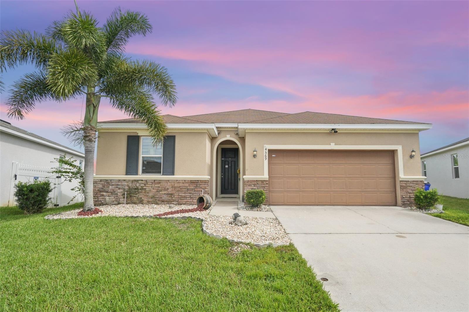 Welcome to this beautiful home in the charming community of Gramercy Farms. Boasting over 2,000 sq. ft. of living space, this 3-bedroom, 2-bathroom property is set on an oversized lot filled with mature fruit trees, including mango, banana, passion fruit, and more, making it your own private retreat.Step inside to find granite countertops and modern light fixtures throughout, bamboo flooring in the bedrooms and stylish tile floors in the main living areas, 9+ ft. ceilings enhancing the open, airy feel, a spacious kitchen with 36-inch cabinets, a large island, and an open view of the family and dining rooms, perfect for entertaining!
The extended covered and screened porch overlooks a serene pond and offers a relaxing country view with no rear neighbors. It’s an ideal setting for family gatherings or unwinding in peace. Conveniently located just minutes from the Florida Turnpike, commuting to St. Cloud, Orlando, and Kissimmee is a breeze