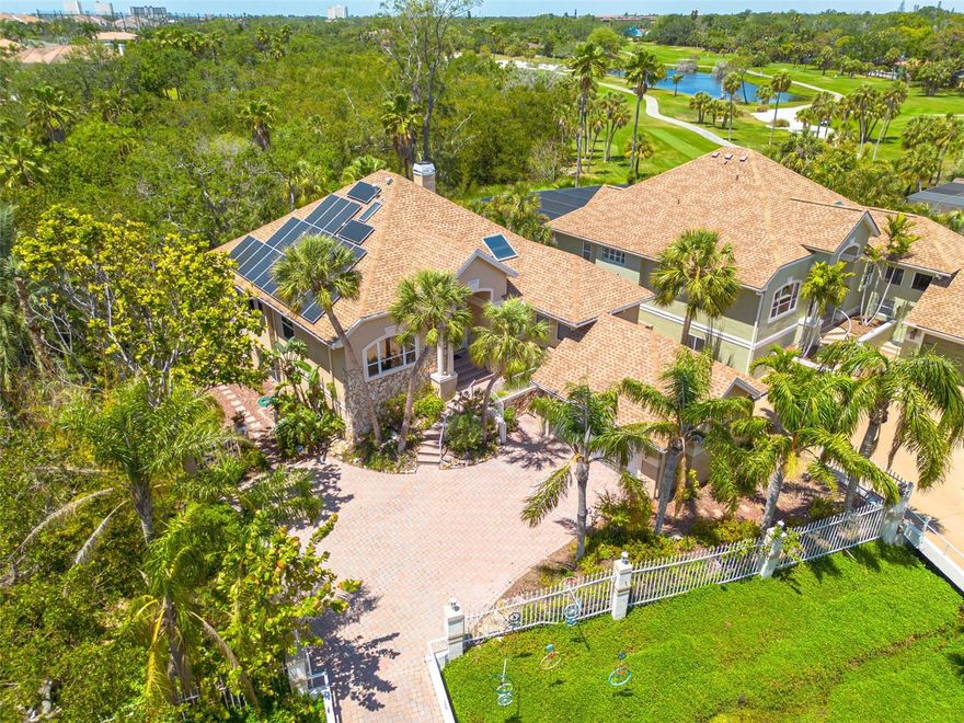 Welcome to a truly nature-inspired retreat, custom built in 1992 by its original builder-owner and thoughtfully designed to live in harmony with its surroundings. Sustainability and peace of mind are key features of this home, with paid-off solar panels (2019) averaging under $100/month in electric costs, a natural gas system, and a 2024 Generac generator. Natural gas also powers the cooktop, fireplace, water heater, and BBQ hookup. Major updates include a 2015 roof and gas water heater, plus HVAC systems (Main and Split Systems) replaced in 2019.  Tucked just outside the gates of Pasadena Yacht & Country Club, this home feels peacefully secluded—surrounded by mature trees, a protected nature preserve, and park views—yet remains remarkably walkable to Gulfport Beach, Beach Blvd, the waterfront recreation center, and multiple nearby parks. With 3 bedrooms, 3 full bathrooms, and an oversized 2-car garage with EV charger hookup, the home balances beauty and practicality. Inside, soaring vaulted ceilings, custom blinds, and refined finishes create light-filled, inviting spaces. The chef’s kitchen features plantation shutters, striking live-edge granite countertops, a paneled refrigerator, a cozy breakfast nook, and convenient access to the indoor laundry room. Designed for those who love to feel immersed in nature, the home offers multiple elevated sitting and entertaining areas, each with its own connection to the outdoors. The primary suite is a tranquil escape with a private deck overlooking the trees, a generous walk-in closet, and a spa-like bath with dual vanities, a garden tub, and a separate shower. The rear family room—fondly known as the “tree house”—features panoramic views of oaks and orchids, a natural gas fireplace, and elegant coffered ceilings, making it a favorite spot to relax or gather. Outdoor living shines with three elevated decks, including a grilling balcony off the kitchen and a spacious deck off the family room—perfect for entertaining, birdwatching, or simply enjoying the quiet beauty of the preserve. The fully finished lower level adds an additional 1,669 sq ft of flexible living space, ideal for a home office, gym, media room, or creative studio, complete with the third full bath and ample storage.  ~ Walkable. Private. Nature-immersed.  ~  This is a rare opportunity to enjoy the feeling of being tucked away in the trees while staying effortlessly connected to everything Gulfport has to offer.