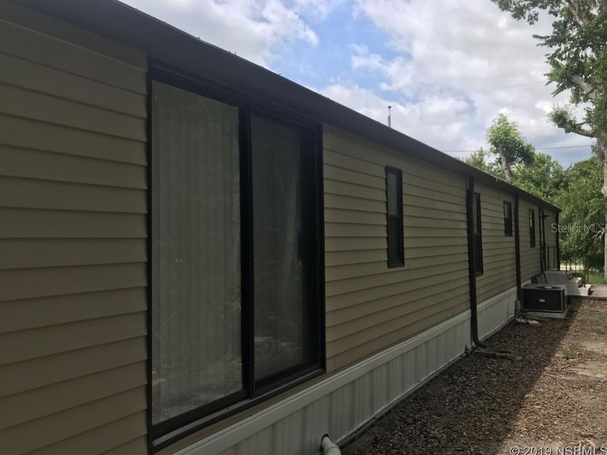 This home has three bedrooms, two bathrooms with a screened porch and carport.  Plenty of room to park the RV or boat.  Owner has painstakingly redone this property with newer roofs, flooring, kitchen equipment/cabinets, screening, walls, paint, and bathrooms, electrical panel, and a/c unit. Home has a detached 30 x 50 garage/workshop/toy barn ready for a new owner.  Centrally located in close proximity to schools, shopping, and all support facilities but still has that off the beaten path with a country vibe.  The canal street and Flagler Ave shopping/restaurant districts are 5-10 minutes away.  The Atlantic Ocean and Intracoastal waterway (boat ramp) and all they have to offer is 10 minutes away.  Do not miss out on a good opportunity to own property with a sizable detached garage that has many possibilities.  You own the land.  No HOA or lot rent.