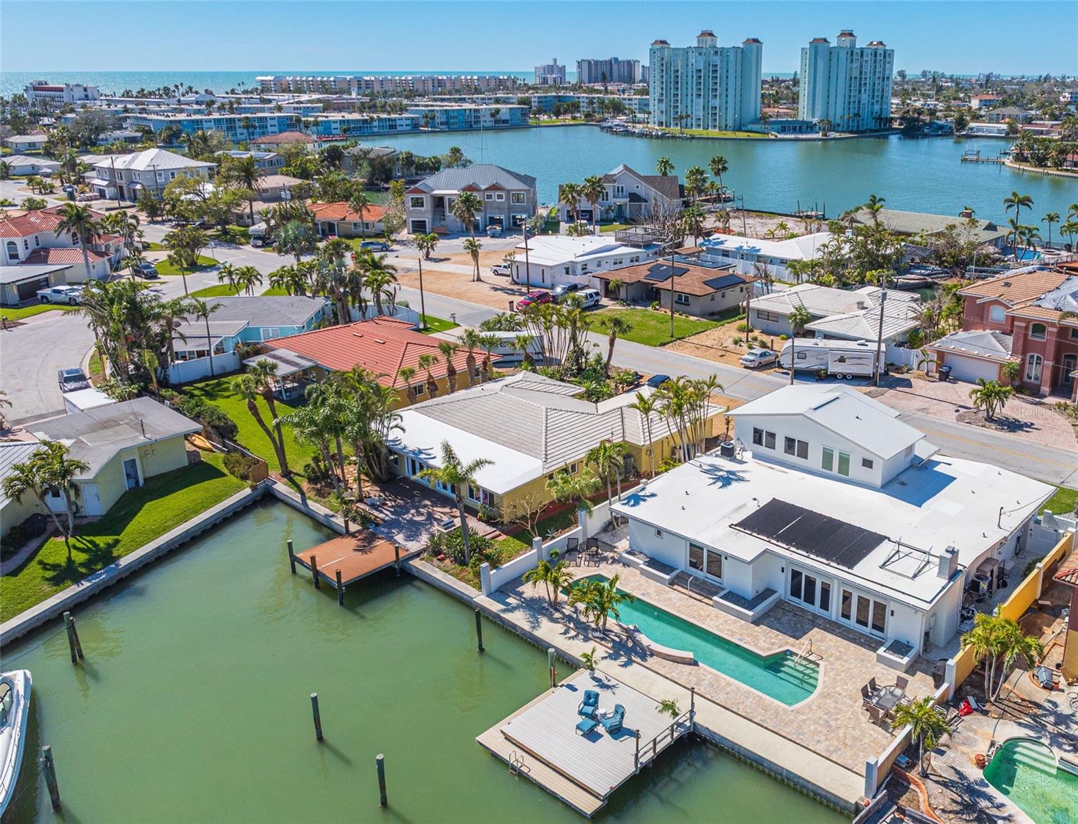 Coastal luxury in the desirable waterfront neighborhood of Bahia Shores, 540 59th Ave offers the quintessential upscale beach lifestyle and is one of the largest homes available at this price point. BEAUTIFULLY RENOVATED, REMEDIATED, AND READY FOR YOUR IMMEDIATE OCCUPANCY. THIS HOME IS LIKE BRAND NEW! Featuring 3 bedrooms, 3.5 bathrooms, a separate office, HIGH CEILINGS, Andersen HURRICANE IMPACT windows and doors, and expansive living spaces, offering water views from nearly every room. Notable upgrades include new HVACs, glistening porcelain tile throughout the foyer, kitchen, dining, and living rooms, new interior paint, custom closet systems in all closets, plumbing, electric, doors, carpet, and updated light fixtures. The new 2025 kitchen boasts a breakfast bar, quartzite countertops, modern cabinetry, ample counter space, high-end Kitchen-Aid appliances, and a large walk-in pantry. Inside laundry room boasts new high end washer and dryer pair.  Inside storage closet provides air conditioned space as a repository to protect your goods from the elements. The oversized dining room is open to the light-filled living room with expansive waterfront views, which features a wood-burning fireplace and Andersen hurricane-impact sliding doors that open to the tropical backyard. The primary suite is a separate private retreat with large windows, a built-in desk with granite countertops, views of Boca Ciega Bay, and a newly renovated ensuite bathroom with dual vanities. The second and third bedrooms are also generous in size and feature their own ensuite bathrooms (each fully renovated). Perfectly positioned, this home offers stunning views of the famous sunrises and sunsets for which St Pete Beach is known. The extended lap pool has a Pebble Sheen finish, a waterfall, and is heated with solar power. Boaters will appreciate the 75 feet of waterfront and the large composite dock with electricity. Additional exterior renovations include new pool pavers, new exterior paint, landscaping and landscape lighting, a new pool pump, and a drainage system in both the front and backyard. With such an ideal location, you can enjoy all the excitement of St Pete Beach! Just minutes or a short boat/golf cart ride to the historical Don Cesar, The St Pete Yacht Club (Pass-a-Grille location), restaurants, and nightlife, and public beach access.
