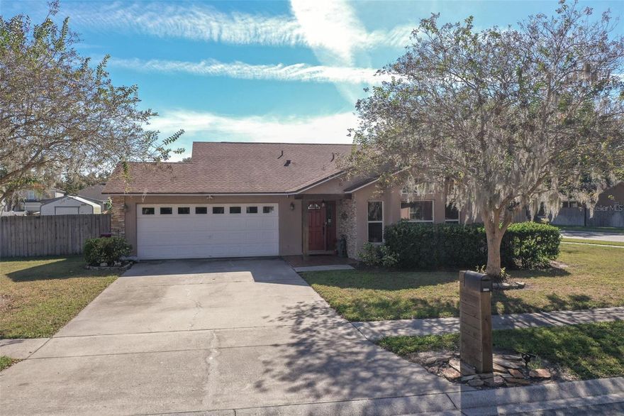 Presenting a three-bedroom, two-bath single-family home that effortlessly blends comfort and charm in a well-maintained setting. This single-story property boasts stucco exterior walls accented with elegant stone veneer, combining strength with timeless curb appeal. Nestled on an oversized corner lot, the home features a fenced backyard adorned with mature trees and a screened back porch, ideal for unwinding or entertaining beneath the open sky.

Step inside, and you’ll discover a functional open layout that seamlessly connects the living, dining, and kitchen areas. Large windows in the living room flood the space with natural light, creating an inviting atmosphere that enhances the beauty of the laminate wood flooring. The kitchen, designed with practicality in mind, is equipped with white cabinetry, laminate countertops, a stylish tile backsplash, and sleek stainless steel appliances. A set of French doors in the dining area opens to the screened porch, allowing for an effortless indoor-outdoor flow while maintaining the abundance of natural light.

The primary bedroom is a serene retreat, featuring laminate flooring, a ceiling fan for comfort, a spacious walk-in closet, and an ensuite bathroom adorned with dual sinks, a solid-surface vanity, and a tub-shower combination. The secondary bedrooms, also boasting laminate flooring and neutral tones, provide a cohesive, move-in-ready feel throughout the home.

Additional highlights include energy-efficient double-pane windows with blinds, owned security system with two cameras, ceiling fans strategically placed for optimal airflow, and an oversized two-car garage with a paved driveway for added convenience. With its thoughtful layout, low-maintenance exterior, and inviting outdoor spaces, this property offers a perfect blend of comfort and practicality, making it an ideal place to call home.