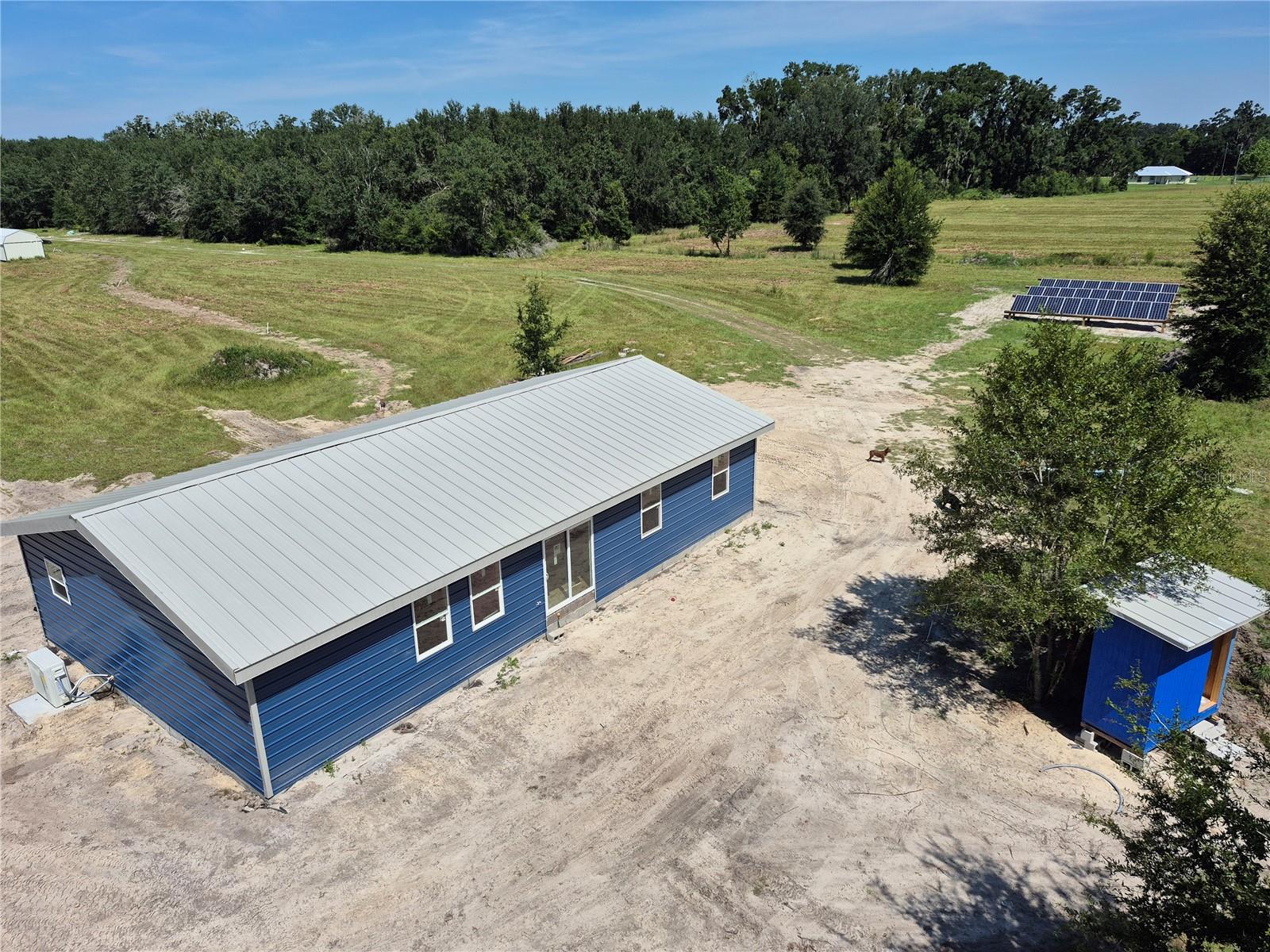New 4 bedroom, 2 bathroom home (~1,800 sq ft) on 3 acres, built in 2025 with durability, efficiency, and independence in mind. Constructed with a standing seam metal roof, metal siding, and an elevated stem wall foundation, the structure was engineered with a continuous load path to withstand Florida’s toughest storms, rated for wind speeds up to 185 mph. This property is fully off-grid. A 9 kW solar array with 60 kWh battery storage provides reliable power year- round, eliminating electric bills and keeping the lights on even during regional outages. A private well and septic system mean no water or sewer bills. Combined with the robust building envelope, this home offers extremely low long-term operating costs. Currently, the structure is classified as an agricultural building, which provides very low property taxes. For buyers who wish, the building can be easily converted to a residence by applying for a Certificate of Occupancy. This gives flexibility: keep taxes low under agricultural classification, or convert when you’re ready to treat it as a standard residence. The home’s layout offers 4 full bedrooms and 2 baths, with open common areas that balance functionality and comfort. Built with high-quality materials and careful workmanship, the property avoids many of the common issues in modern housing—no cheap finishes, no short-lived shingles, no design oversights that compromise comfort. The property is offered with 3 acres at $279,000, with the option to expand to 6 acres if desired. Whether kept as a homestead, a sustainable family residence, or an investment property, this land offers privacy and future development potential. This is a rare opportunity in Dixie County: a newly built home that is strong, efficient, independent, and cost-effective to own. Buyers seeking long-term value, sustainability, and resilience will find this property unmatched in the market.