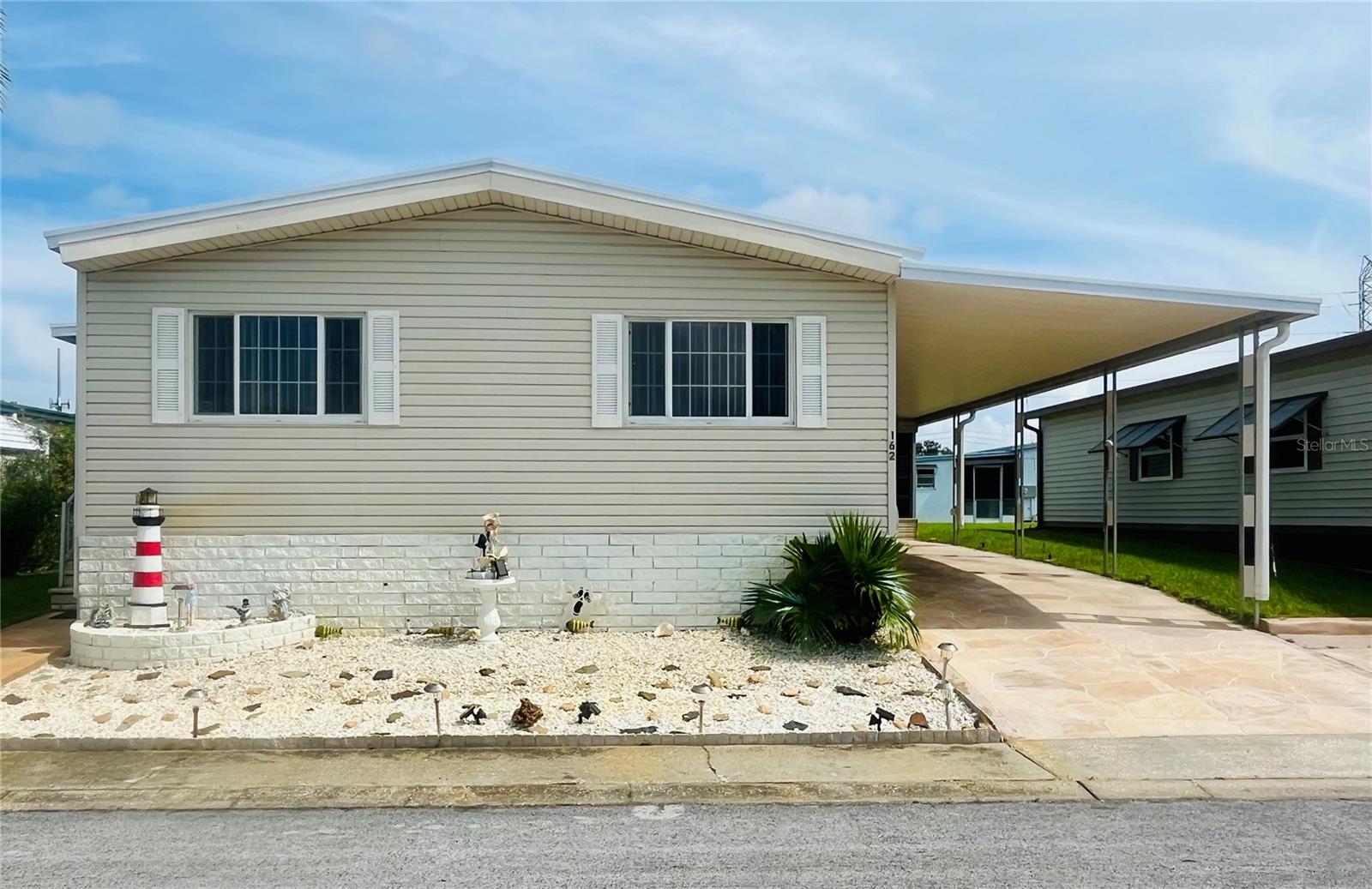 Spacious and unique 3 bedroom/2 bath double wide manufactured home. This large home offers 1464 living area square footage and sought after split floor plan offering both space and privacy. Step inside to an open and airy layout that includes the primary suite on one side and the guest bedrooms on the other. Large eat in kitchen, dining room, and a welcoming living room with vaulted ceilings and a fireplace. Laundry located inside the home. Enjoy indoor-outdoor living with a screened side porch, covered 2 car covered driveway, and maintained landscaping. This move in ready home is located in Blue Jay Estates, an active 55+ community where you own your land! It is situated in a non-flood zone and there is no lot rent! A low monthly fee of $230 a month includes escrow reserves, water, sewer, trash, lawn care, and more! Schedule your showing today. Blue Jay has a very active social club, lots of activities, a heated pool for year-round enjoyment, shuffleboard and Bocce courts. There is a designated area where you can park your boat or R/V at no additional fee if space is available when requested. Near beaches, the Pinellas trail, parks, shopping, medical centers, and airports