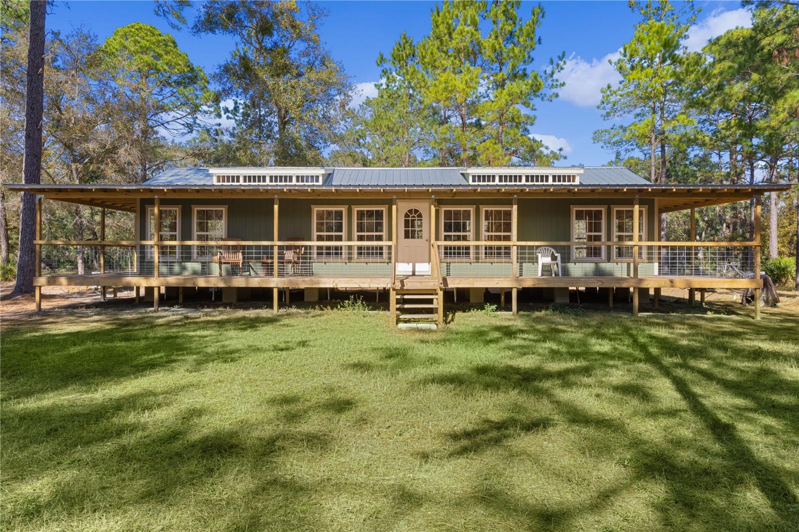 **Significant price reduction on this hidden gem! Below appraised value!!** A small cottage on 18.8 acres surrounded by all natural, native growth, right in the heart of Florida yet a quick easy drive to major roadways, the Florida Turnpike, interstate, and, 30 minutes to the Gulf. This cabin was custom designed by the owners and assembled onsite. So charming and inviting on the outside but wait til you see the inside! All custom, everything in it from the heart pine walls and ceiling, to the 1960's Sears Electric stove that works like a charm, to the aqua refrigerator, to the breakfast bar counter with the raw edge, to the copper sink, but wait til you see the bathroom! All the details. The bedroom is full of windows for letting in all the outside light, day or night and has a walk-in closet. It's like sleeping in a tree house. Custom lighting throughout and stylized ceiling fans just keep adding to the setting. There is a small pantry for additional storage. Barn style sliding doors open to the walk-in closet and bath. Outside there is a walk-around porch, with railing and wire underneath to keep the littles and pets safe. You can sit on the porch in the morning and have your coffee to watch the sunrise and move to the other to watch the sunset. Then, there's more. There is an additional shed with a loft that stores part of the solar equipment but can be used for small storage or bunkhouse. As shown in the photos, this property is solar powered. Fully functional. There is a breaker box that also has the set-up to convert to generator power or if the owner chooses to run electric in, can convert to electric just with the flip of the handle. There are on demand hot water heaters. A short distance away from the cabin, there are three covered storage containers for equipment or materials, or toys, on a 20x25 concrete pad. The solar powered well is also there. This property is unique, for sure, waiting for the family looking for a week-end camp, or for the off the grid preppers, Airbnb, the list is long. Full of wildlife, wildflowers, and Mother Nature. Accessed by a winding drive thru the native woods, you would never know it's there. This property did not flood during the hurricane. It is well worth the look! Equal Opportunity Housing.