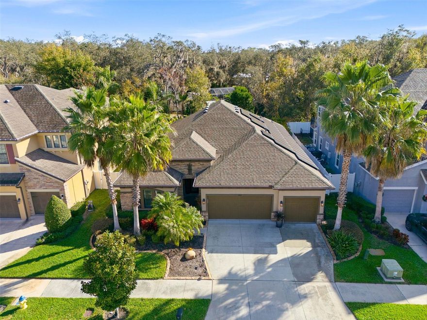 Located behind the gates of The Manors at Forest Glen, this highly upgraded 4-bedroom, 3-bath WestBay-built residence with a three-car garage offers architectural distinction, premium finishes, and modern smart-home features rarely found in the community. A formal foyer with 12-foot ceilings is anchored by a stunning mahogany entry door with privacy glass panel and hand-forged wrought iron detailing, setting the tone for the home’s refined design.

The foyer opens to a dramatic great room with a coffered ceiling accented by hand-carved wood beams, while plantation shutters throughout and level 5 stone countertops elevate the home with timeless sophistication. The open-concept kitchen, dining, and living areas flow seamlessly to oversized sliding doors leading to a screened lanai and pavered rear patio featuring an inground pool and spa, complemented by a custom outdoor kitchen with built-in grill and stacked stone backsplash and feature wall—ideal for entertaining and year-round outdoor living.

TechSmart features include a smart thermostat, smart-controlled LED lighting within the screened pool enclosure, and powered roll-down hurricane-rated doors for rear windows and sliders. The owner’s retreat offers a spacious walk-in closet, dual vanities, and a large walk-in shower. An oversized laundry room features custom cabinetry, quartz countertops, an oversized sink, and a smart washer and dryer.