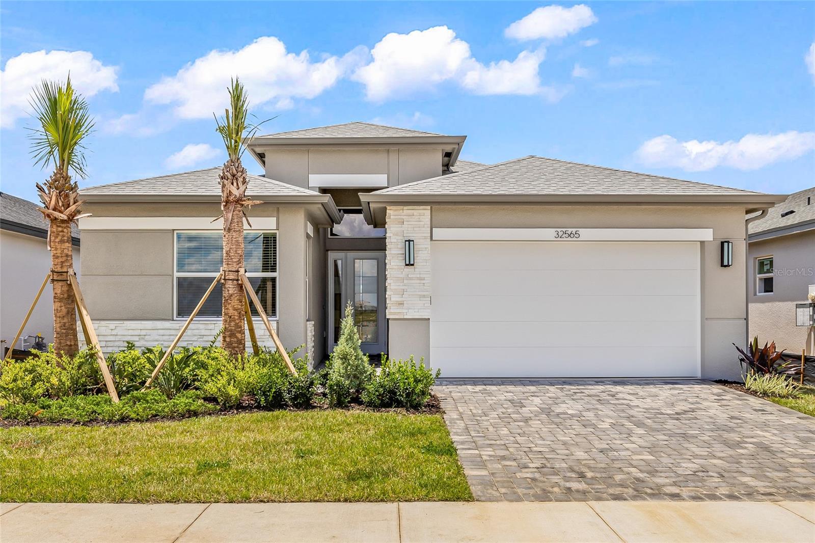 Be the very first to live in this brand-new, move-in-ready Jasmine model by GL Homes—designed for relaxed Florida living in the highly sought-after Valencia Ridge 55+ community. This never-lived-in home blends elevated finishes with thoughtful upgrades, offering comfort, convenience, and class in every square inch. Convenient 3 bedrooms plus a den/office, 3 full bathrooms, and a 2-car garage. Inside, you'll find a modern open layout with premium recessed lighting, Porcelain Tile floor throughout, upgraded smart garage door opener with built-in camera and battery backup, designer glass front entry door with sidelite, and multiple HDMI preps with concealed wiring for sleek flat-panel TV installation. This is a natural gas community offering energy-efficient appliances in the kitchen with full overlay cabinetry, quartz countertops and backsplash.Primary suite features two closets and a spacious bathroom with dual vanities, walk-in shower and linen closet. The home also includes a variable speed HVAC system with Wi-Fi-enabled humidity control for energy-efficient comfort. Exterior highlights include full-house seamless gutters, a screened-in covered patio and a pre-plumbed summer kitchen stub-out with gas, electric, and water—perfect for future outdoor entertaining. Finished in a timeless color palette with Silver Birch roof shingles, Arctic stone accents, and Glacier pavers, this home blends elevated finishes with practical upgrades. Valencia Ridge offers a resort lifestyle which will soon offer a 29,000 sq ft clubhouse, full service restaurant with indoor and outdoor seating, resort style pool with covered cabanas, lit pickleball, tennis, and bocce ball courts, fully equipped fitness center, walking trails, and an active social calendar. No need to wait—this one is ready now!