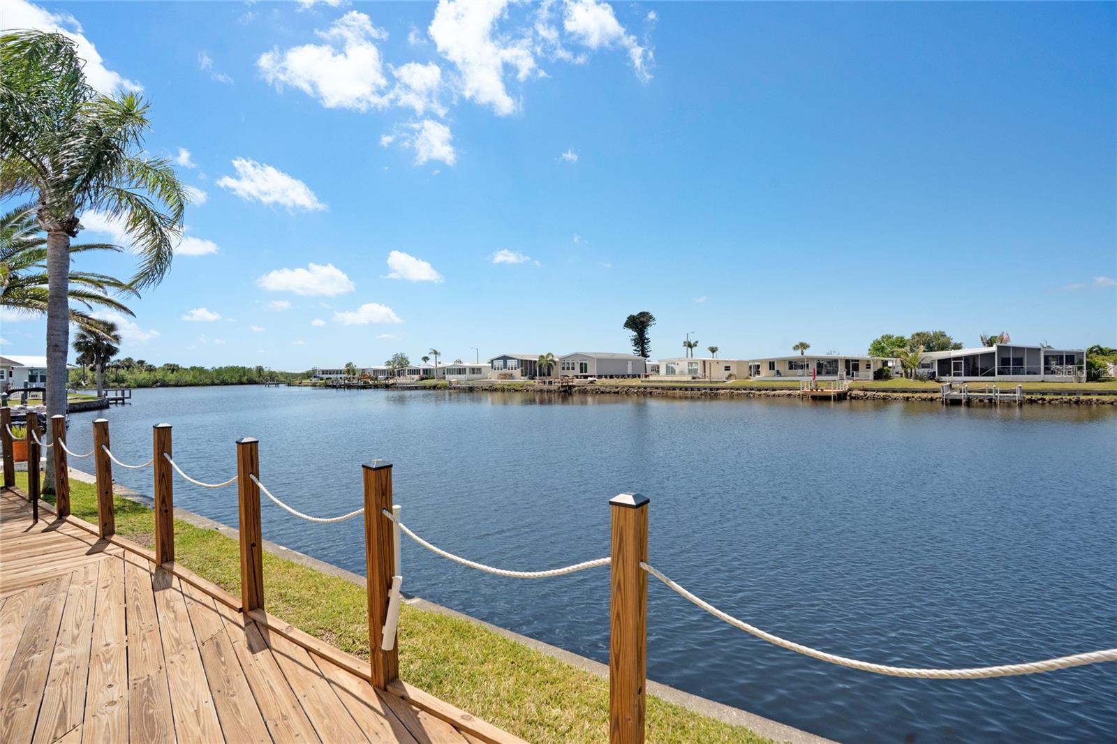 PRICE REDUCED! Bank Financing Now Available on this Stunning and spacious remodeled WATERFRONT home on a wide canal in 55+ Harbor Cove just $99 per year! Delight in the INCREDIBLE VIEWS from this FURNISHED 2 bedroom, 2 bathroom 1,344 square foot residence located on the MAIN CANAL leading to the marina and the GULF via the Myakka River. Jump in your boat and head out for fishing adventures or just watch others pass by perched from your amazing Florida room which maximizes water views through abundant windows. Viewing wildlife from this spot is a rewarding everyday experience. Choose between the multiple areas that have been created both inside and out to relax, dine and entertain. Enjoy the addition of the screened room in the evenings or relax at the waters edge from your large outdoor deck. The open concept living space has been thoughtfully remodeled with cathedral ceiling, vinyl plank flooring, a large bright kitchen with island, dining room built-ins and attractive furnishings. The primary bedroom retreat is large with king bed and barn door to the ensuite bathroom with walk-in shower and closet. A guest room also serves as an office and has an extra lockable closet for securing items should you choose to use as a rental. Lots of updates including roof, gutters, vapor barrier, skirting, subfloors, water heater, water line, washer, dryer, fresh paint, etc. Harbor Cove has a two-story clubhouse overlooking the 90-slip marina and hosts dances, shows, holiday gatherings, picnics, card and trivia games, classes and more. With two swimming pools, hot tub, fitness center, craft rooms, and multiple sports courts you'll have many options for activities. It's just a short drive to I-75, beaches, golf courses, restaurants and quality healthcare. Take advantage of this rare opportunity to own this beautiful home in a prime location for only $99 per year. Call to schedule a showing today.