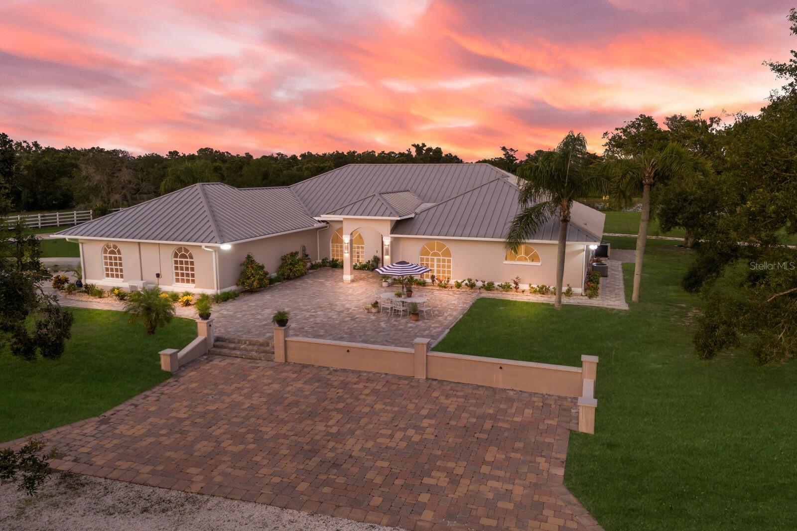 One or more photo(s) has been virtually staged. Welcome to your dream equestrian estate in East Sarasota County, where luxury living and wide-open freedom come together on almost 26 cleared acres! This modern, sprawling ranch offers an exceptional lifestyle for horse enthusiasts and those seeking space, privacy and relaxed living in one breathtaking package. Zoned for agricultural use and free of any community restrictions, this property is a rare blend of elegance and enterprise, ideal for equestrian professionals, agri-business visionaries or buyers seeking a distinctive Florida homestead with broad potential. Perhaps you might consider an opportunity to host weddings or other social events. Arrive through majestic gates leading to a grand courtyard designed with a nod to European influences. This 3,862-square-foot custom residence harmoniously blends modern, upscale finishes and everyday livability with a curated blend of modern architecture offering flexible living options. The home boasts four spacious bedrooms, three full baths, soaring ceilings and expansive glass that fill the home with natural light and sweeping views. The luxury living spaces include a standout gourmet kitchen that delivers for culinary enthusiasts. Anchored by an oversized quartz island, custom-wood cabinetry, dual cooktops/wall ovens, and Sub-Zero refrigeration-ideal for elaborate entertaining or everyday use. Your spa-inspired primary suite invites relaxation at close of the day with a soaker tub, walk-in shower, split vanities with quartz counters and dual custom closets. The heart of the home opens seamlessly to an outdoor oasis featuring a show-stopping heated pool complete with a Bayu Swim Spa. The expansive lanai is framed by a panoramic clear-view screen where you can enjoy uninterrupted vistas of rolling acreage—ideal for peaceful mornings or lively evenings entertaining under the stars. Additional spaces include a large living/office area and a versatile library/game room opening to the lanai, providing added entertainment options for work or entertainment. Equestrians will be in awe of the nine-stall custom barn, designed with the serious horse enthusiast in mind. Wide aisles, wash racks, tack room, and easy access to riding pastures make this a horse lover’s paradise. The barn is incredible! Prior owners used this property for dressage training. The charming two-bedroom, one-bath guest house offers a private retreat, ideal for extended guests, multigenerational living or income-producing potential. The home includes a spacious, updated kitchen, private patio, laundry room and carport. Enjoy peace of mind with these additional upgrades, such as metal roof on the main home, barn and guest house. Outside of a flood zone and unaffected by recent storms, this private estate offers broad residential and possible commercial flexibility, all within minutes of Lakewood Ranch/Sarasota amenities. Whether you're a seasoned horse enthusiast, love to host guests or find yourself longing for elegant country living, this extraordinary property is the ultimate blend of luxury, lifestyle and land in a setting that's magical. No HOA and no CDDs. Experience all possibilities. Schedule your private showing today and live the lifestyle you’ve been dreaming of. Tour it, love it, own it today!