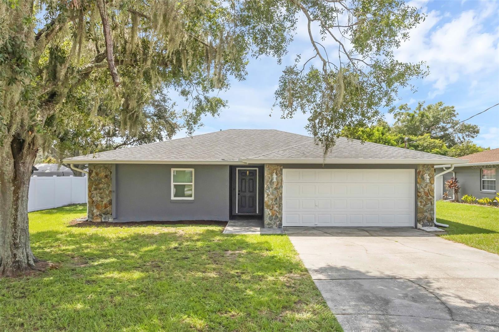 Welcome Home to Charm & Upgrades! This cute three bedroom/two bath home is situated on almost a quarter of an acre and has so much to offer — fresh paint, a brand new refrigerator, range, hot water heater, air conditioner, gutters, garage opener, and dual pane windows/sliding glass doors (with a lifetime warranty on the screens and windows) plus a newer roof (2019) and luxury vinyl plank flooring throughout (2023). The beautiful stone, wood-burning fireplace is the focal point of the home (where you can enjoy a warm fire on cool nights) and the open patio is the perfect place to cook-out while the family or your guests are having fun in the large backyard. Kathleen Elementary & Kathleen Middle School are a short walk away and it's a quick drive to beautiful Bonnet Springs Park. There is no HOA in this neighborhood. This lovely place would make a great starter or retirement home. While the feeling of being in the country abounds, it is conveniently located near Interstate Four, Lakeland Linder Airport, shopping, restaurants, and entertainment. 3608 W. Wheeler Road in Lakeland, Florida is a wonderful place to call home!