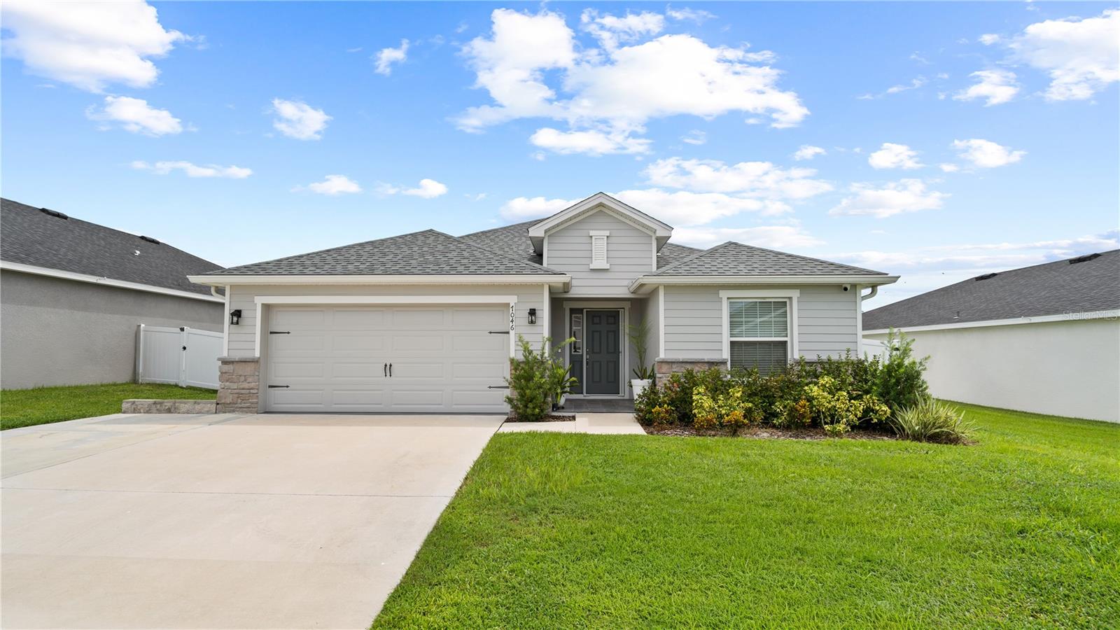 Welcome to this beautifully maintained, one-owner home in a sought-after gated community! Featuring 4 spacious bedrooms, 2 bathrooms, and a 2-car garage, this move-in-ready residence offers comfort, style, and privacy all in one.
From the moment you arrive, the paved driveway and charming front porch create a warm and inviting first impression. Inside, luxury laminate plank flooring flows seamlessly throughout the main living areas, enhancing the open-concept design.
The heart of the home is the bright and modern gourmet kitchen, complete with large countertops, sleek cabinetry offering ample storage, and a large center island with a built-in sink and breakfast bar perfect for casual dining or entertaining. Stainless steel appliances include a refrigerator, microwave, dishwasher, and range. A separate dining area provides additional space for family meals or formal gatherings. This home includes a professionally installed 120V connector generator system, providing reliable backup power during outages. The setup features a dedicated inlet box and manual transfer switch, allowing you to run essential circuits such as lighting, refrigerator, internet, and key outlets throughout the house
The spacious living room opens directly to a fully enclosed back porch with glass windows and a door, an ideal spot to relax, enjoy a morning coffee, or entertain guests year-round.
The primary suite is a true retreat, featuring an oversized walk-in closet and a well-appointed ensuite bathroom with dual vanities and a separate shower.
Step outside to your private, fully fenced backyard, complete with vinyl fence, paver patio, and plenty of space for pets, play, or outdoor entertainment. Whole-House Water Filtration System, Provides clean water quality for drinking, cooking, and bathing. Smart Security Features includes a Ring video doorbell and a fully integrated outdoor security camera system, offering real-time monitoring, motion alerts, and remote access