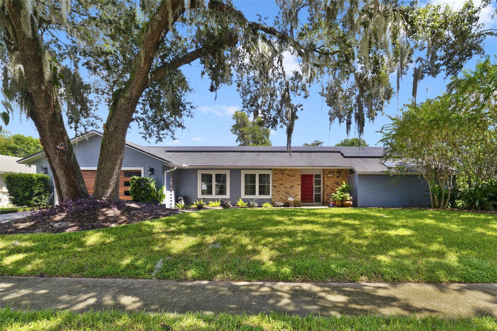 Welcome to Lake Mary Jess Shores – a charming lakefront community with convenient lake access just down the street. Nestled within a private enclave of only 29 homes, this quiet cul-de-sac neighborhood is lined with mature oak trees, creating the quintessential Old Florida atmosphere. Perfectly located just 5 miles from Downtown Orlando and SR-408, 3 miles from I-4, and minutes to SR-528 and the SunRail, you’ll enjoy the best of both tranquility and convenience.
Step inside to a massive great room with soaring vaulted ceilings and a handsome brick fireplace, setting the tone for this inviting home. Rich dark wood floors flow throughout the main living areas, the primary suite, and two additional bedrooms, adding warmth and character.
The kitchen is a chef’s dream and will truly impress, boasting crisp white cabinetry, quartz countertops, stainless steel appliances, and an oversized island with bar seating. It overlooks a second living area with French doors that open to a beautiful brick paver patio and large private backyard—perfect for relaxing or entertaining. Off this space, you’ll find the fourth bedroom, ideal as a home office, complete with French doors offering views and access to the backyard.
The primary suite is generously sized to accommodate oversized furnishings and includes a huge walk-in closet, dual vanities, and a large walk-in shower.
This home effortlessly combines charm, modern updates, and thoughtful design, with plenty of room for everyone to spread out. GREAT ROOM AND DINING ROOM FURNITURE IS INCLUDED!