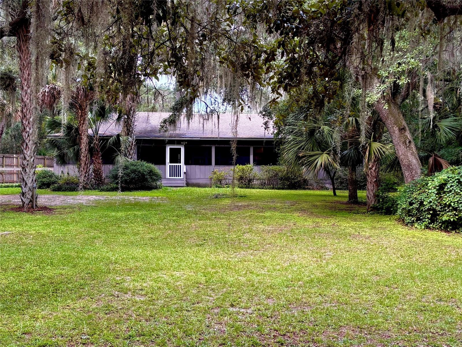 Welcome to your new home in Historic Hawthorne Florida ! Jump back in time as you experience what old Florida must have felt like. With almost 3 acres of Majestic Live Oaks, Incredible Palm and Magnolia Trees, as well as Citrus, Sweet Fig and Loquat. The property is private and secluded. This traditional Ranch style home has 3 bedrooms 3 baths is spacious, charming with a modern feel. The fully screened in wrap around 3/4 porch is ideal for relaxing in the fresh country air. The house has been recently remodeled, Some upgrades to include,wood and tile flooring, kitchen appliances, New Gas range, granite countertops custom bar made from Acacia Wood. The primary bedroom is oversized and has been totally transformed from a 2 car garage, has all New Wood flooring, his and hers closets and new bathroom. The bedroom could also double as a large florida or family room with plenty of windows new sliding glass doors that open up onto the colorful landscaped backyard with a large chicken coop that will hold up to 20 chickens for farm fresh eggs every morning. The property gently slopes away from the home property is fully fenced and cross fenced. Home sits across from Holden Park Road boat ramp for easy access to Holden Pond, Moss lee and little Orange Lake great for fishing, tubing, wake surfing, kayaking etc. Property is centrally located between Gainesville, Ocala and Palatka. Home is just minutes from Downtown Hawthorne with plenty of restaurants, shopping, public library, schools, multiple public parks and plenty of recreational lakes. Just a few minutes to the starting zone to Rails To Trails, over 25 paved miles for bike riding, walking and running enthusiast. Easy to show. * possibly furnished* ask agent for details.