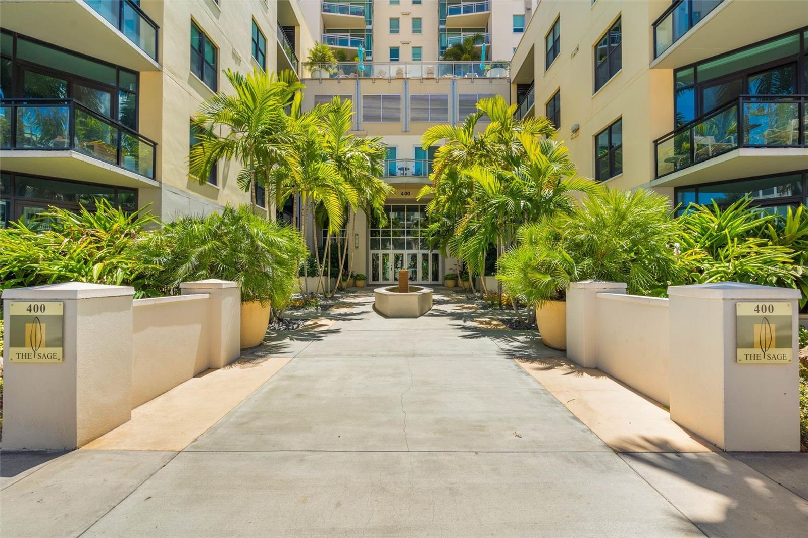 Experience elevated urban living in this light-filled 1-bedroom, 1.5-bath + den condo with a den, located in the heart of downtown St. Petersburg at The Sage. Spanning 1,055 square feet, this spacious residence features gleaming wood floors and stylish paddle ceiling fans that complement the open, modern layout. The kitchen is designed with rich wood cabinetry, sleek stainless steel appliances, bar seating with pendant lighting, and included stools—perfect for casual dining or entertaining guests.
A private balcony offers beautiful views of the resort-style pool and the vibrant city below, with access from both the living room and bedroom. The versatile den includes built-in bookshelves and a closet, making it ideal for a home office, guest space, or creative studio. The primary suite features a walk-in closet, and a spa-inspired en suite bath with a soaking tub, separate glass-enclosed shower, and dual glass vessel sinks atop a designer vanity.
Additional conveniences include a side-by-side washer and dryer with extra shelving in-unit, and an interior storage unit located just down the hall. This condo also comes with two covered, side-by-side garage parking spaces—tucked away from the opening for added protection from the elements.
Residents of The Sage enjoy premium amenities such as a stylish pool deck, state-of-the-art fitness center, grilling station, and secure building access. All just steps from award-winning restaurants, boutique shopping, art galleries, waterfront parks, and the vibrant energy of downtown St. Pete.