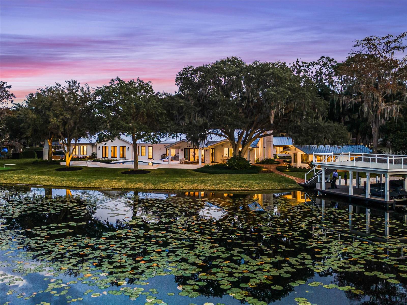 Welcome to 50 Forest Street in picturesque Downtown Windermere, situated on arguably one of the best water-front lots on the Butler Chain. This one-of-a-kind location is full of live oak trees on three adjoining lots creating unparalleled 180-degree postcard views of Wauseon Bay. The sprawling one-story 7,300 square foot home underwent a complete remodel that was completed in 2023 where it was taken down to the studs and rebuilt with zero expenses spared. The result is a coastal-chic design including new tongue and groove ceilings with distressed beams, new wood/gas burning fireplace and new pool among numerous other upgrades. The grounds are incredible and deliver a true embracement of the Florida lifestyle. Hop on your boat and explore the Butler Chain of Lakes, play on your sand beach, relax poolside, utilize the new summer kitchen and pizza oven, relax with a drink by the outdoor fireplace and enjoy the beautiful sunsets over the lake or practice your short game on your own new putting green. New metal roof and commercial gutters, new saltwater pool & spa, new boat dock with 2 covered slips and 2nd story party deck, all new Sierra Pacific windows and doors. The all-new dream kitchen is the heart of this home and a true showstopper with Kingdom Custom Cabinetry, Thermador appliances, Waterstone unlacquered brass faucets and hardware and hidden custom coffee bar. Media room with projector screen and automatic blinds creates the perfect place for movie nights while utilizing the custom wet-bar with wine fridge and refrigerator drawers. Master suite includes an enormous bedroom with reading nook, grand bathroom and two walk-in custom closets. C4 system installed for the smart home technology you would expect. TESLA SOLAR PANELS cut deep into the electric bill. Natural Gas Genrac Generator for additional peace of mind. A SEPARATE DETACHED 1 bedroom, 1 bath GUEST HOUSE with its own patio overlooking the lake is just another unique and amazing feature of this estate. Could be an ideal in-law suite, office, gym or residence for live in nanny. Plenty of parking with 4 car garage and several paved parking pads on property. NO HOA and in the heart of the Town of Windermere, delivering the convenience and quality of life that makes it one of the most desired places to call home in Central Florida. Located minutes from Sand Lakes famed restaurant row, Disney, Universal Studios, International Drive and all the major expressways. For those not aware, the Butler Chain of Lakes is a 5,000-acre chain of freshwater lakes consisting of 13 canal connected lakes spanning 3 entire zip codes. 50 Forest is on Wauseon Bay of Lake Butler, one of the most sought-after areas of the chain. Hop on your boat anytime and be immediately on the best lake in the chain... delivering the best arena for water sports and championship bass fishing in the area. Sought after K-12 school district and several private school campuses in every direction. Opportunities like this do not come around often, there is no other like it!