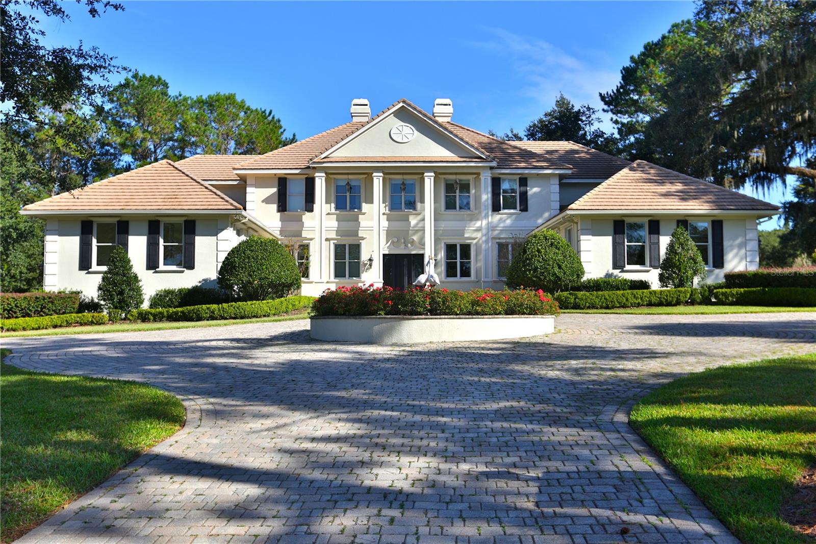 Nestled on the challenging 15th green of the Golden Ocala Golf Course, this stunning estate offers breathtaking views of the course, bridge, and pond. A circular driveway with pavers and a fountain welcomes you to this impressive two-story home.
As you enter, the floor-to-ceiling windows offer stunning views of the pool and golf course. Lavishly appointed, this stately residence features approximately 5,912 square feet of living space, with options for five or six bedrooms, five full baths, and one half bath.
The beautiful formal living room features a double-sided fireplace, soaring ceilings, expansive walls, and French doors that open to the pool area, offering incredible views. The formal dining room features a butler's bar, a fireplace, and a wall of windows that fill the space with natural light while showcasing the same stunning views.
The chef's kitchen is equipped with Wolf double ovens, a Sub-Zero refrigerator, a Wolf gas cooktop, and a center island complete with a prep sink, two refrigerator drawers, and a microwave. The main island includes dual sinks, two dishwashers, and a raised bar area for additional seating. Nearby, an informal dining alcove with large windows provides a delightful space for family breakfasts. This charming kitchen opens to the family room, serving as the home's central gathering area.
The owner's suite on the first floor boasts a sitting area, dual walk-in closets, and French doors leading to the pool and covered lanai. The spacious bath offers dual sinks, a soaking tub, and a large private shower. An adjacent room can serve as an office, nursery, gym, or any other purpose you choose.
A private elevator or staircase leads to the second floor, which is divided into two wings. One wing features a conversation or TV area with a mini refrigerator and sink, along with bedrooms two and three, both of which are en-suites. The other wing contains bedrooms four and five, equipped with private dual vanity areas and a shared bath. A bonus room on this level could serve as a playroom or an additional bedroom. Two of the upstairs bedrooms open to private balconies that overlook the pool, pond, and 15th hole.
Enjoy the covered lanai, summer kitchen, and beverage bar, which provide ample seating and conversation areas surrounding the pool. Alternatively, you can unwind in the adjoining shade garden. The home features two garages, each accommodating two cars, with one offering easy access to the kitchen and the other serving the owner’s wing.
Enjoy the covered lanai, summer kitchen, and beverage bar, which provide ample seating and conversation areas surrounding the pool. Alternatively, you can unwind in the amenities at Golden Ocala, which include a clubhouse, pool, tennis courts, a fitness center, a spa, and both casual and fine dining options. With access to the World Equestrian Center just a golf cart ride away, you can enjoy various activities and horse events, dine at exquisite restaurants, visit with friends, and explore nearby shops.