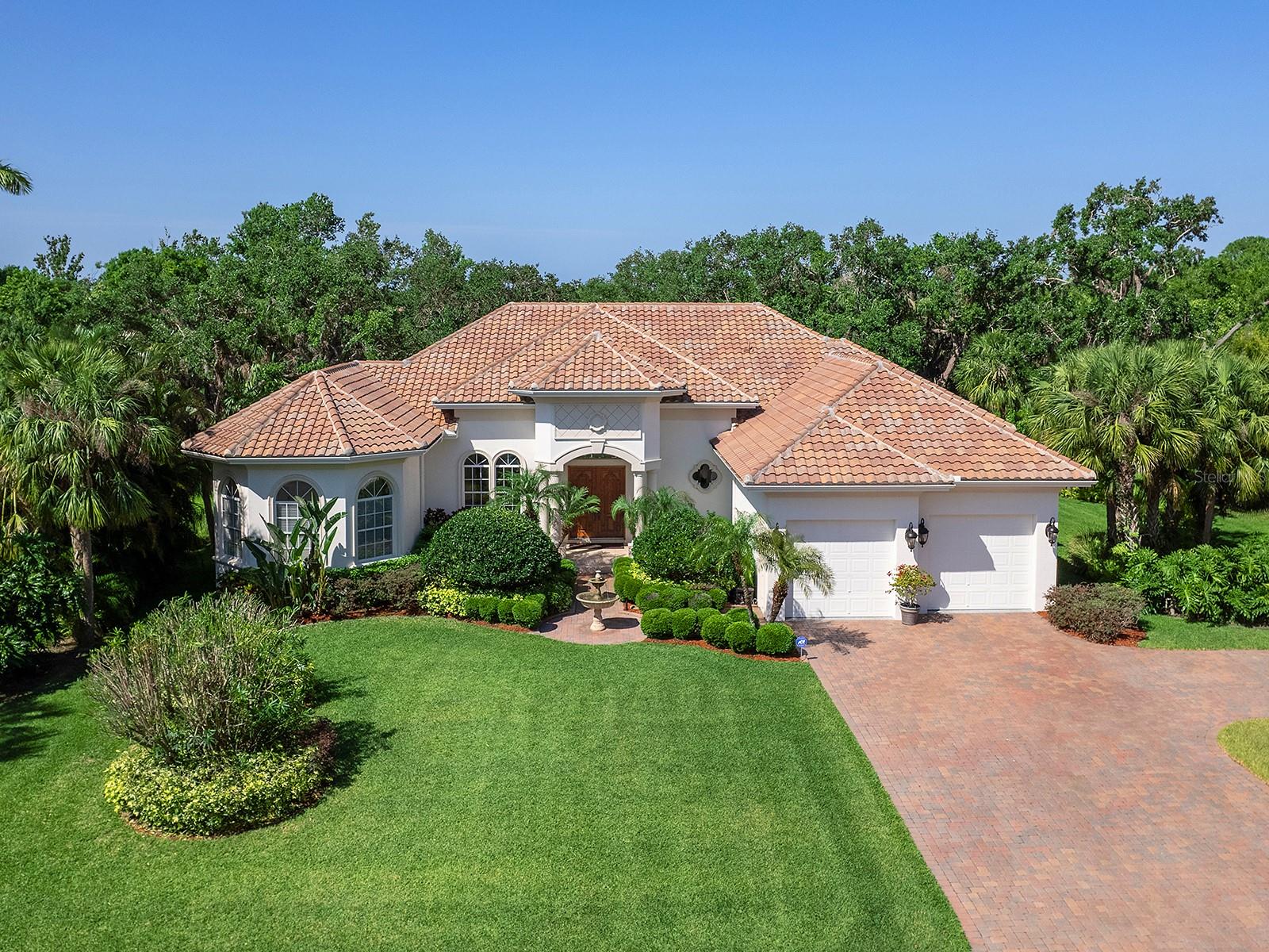 Welcome to this beautiful custom-built residence in a wonderful golf and country club community in Southwest Florida. Offering three spacious bedrooms, three and one-half baths and a versatile office/den, this home is thoughtfully designed for comfort, style and functionality - all set on a large private lot filled with lush landscaping, vibrant wildlife and serene natural beauty. From the moment you arrive, you'll be charmed by the tranquil sound of a fountain and the refined presence of mahogany double-entry doors. Inside, the home is filled with natural light streaming through numerous arched windows, glass doors and transom windows. Twelve-foot ceilings, accented by 9-inch crown molding and decorative tray ceilings, enhance the sense of open space and luxury. The main living areas feature travertine tile flooring with 6-inch baseboard molding for a tailored finish. The heart of the home is a chef's dream kitchen with a six-burner double-oven gas range, maple cabinets with soft-close doors, tile backsplash, granite countertops and a bar height counter with elegant pendant lighting. Centrally located, the kitchen opens seamlessly to the great room and family room – ideal for everyday living and effortless entertaining. Pocketing sliders in both living areas lead to the lanai, creating an inviting indoor-outdoor connection for hosting gatherings or enjoying quiet evenings. The family room is enhanced by a full wet bar, offering additional space for relaxation and hospitality. Extensively updated in 2024, this home boasts three remodeled en-suite baths and half bath, a refreshed laundry room and a modernized mud room. Additionally, the primary bedroom suite HVAC, refrigerator, dishwasher and microwave were replaced. The light-filled primary suite offers French doors that open to the lanai and pool, as well as built in wall shelving, dual vanities, a freestanding tub and a beautifully tiled walk-in shower. Step outside to the inviting paver lanai, with the refreshing pool and spa, or relax under the covered seating area with the gas fireplace and cypress ceiling to enjoy a peaceful retreat with serene views of the private backyard. An air-conditioned four-car garage includes an epoxy floor, built-in cabinets with a workbench and a spacious storage closet. Constructed with quality in mind, the home features a 4-foot stem wall, abundant built-in cabinetry, solid-core doors, ¾-inch rigid insulation, and substantial 1-inch-thick trim with no finger joints. Importantly, the property experienced no flooding during the 2024 hurricanes, according to the owner. Optional membership to the golf and country club includes access to championship golf, clubhouse dining, community pool, fitness center, bocce ball, pickleball and tennis. Just minutes away, there are kayak, canoe and boat rentals, a public boat ramp, food and drinks, live music and waterfront cabins. This exceptional home is a blend of refined comfort, privacy and natural surroundings, ready to welcome the next owner.
