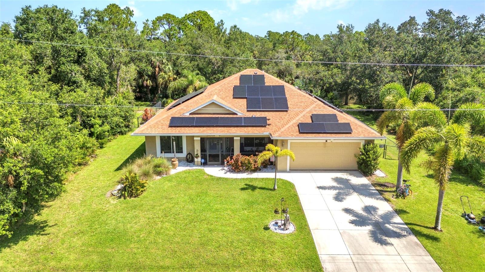 Looking for a beautifully updated pool home with extra land and privacy? This immaculate 3-bedroom PLUS den/office home, nestled on THREE LOTS totaling .69 ACRES, checks all the boxes! Surrounded by lush nature, this property offers space, serenity, and modern upgrades throughout. You'll love the NEW ROOF (2024), IMPACT WINDOWS (2023), and a smart IRRIGATION SYSTEM (2026)—all providing peace of mind and added value. Step onto the welcoming 19x8 screened front porch, accented by the same stylish pavers that continue around the heated saltwater pool (new in 2013), creating a seamless and upscale outdoor living experience. The back lanai is a private retreat, featuring a large covered area with access from the living room, primary suite, and office/den, leading to a tranquil pergola-topped patio surrounded by park-like landscaping—perfect for relaxing or entertaining. Inside, the split-bedroom floor plan offers privacy for all, with the den easily converting into a 4th bedroom if needed. The heart of the home boasts cathedral ceilings and an open layout that flows from the formal dining area to the living room, breakfast nook, and spacious kitchen with a sit-up breakfast bar and pantry closet. A shiplap-accented electric fireplace adds charm and warmth to the main living area. Enjoy easy-care wood-look flooring throughout—no carpet anywhere! Plus, the paid-off solar panel system (installed in 2020) keeps electric bills impressively low (averaging just $45/month). Additional features include a 2-car garage and two storage sheds (16x10 and 12x20)—both with electric service, providing over 400 sq ft of added storage or workshop space.
This home truly offers it all—space, style, updates, and efficiency—all in a peaceful, natural setting. Don’t miss it!
