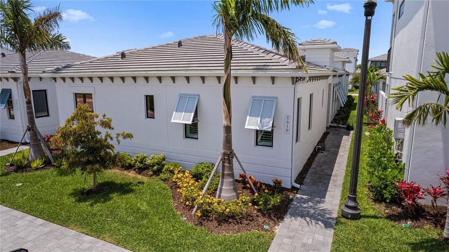 Escape the Traffic and Enjoy the Beach Lifestyle!  
Imagine living just steps from one of Florida’s most beautiful spots—without the hassle of traffic. Welcome to AQUA, a luxurious, **FULLY FURNISHED**, private community designed for those who crave the perfect blend of location and comfort. Experience the magic of AQUA’s stunning 4-acre Lagoon Style Pool, with access to restrooms and lockers, all just a short walk from your doorstep. Bring your paddleboard, kayak, cooler, and beach towel—this oasis is your new favorite spot to relax and unwind all day long.  
Pictures can’t capture all the beauty—come see for yourself!
Located at 5910 Red Mangrove Lane, this Sea Grape model home is a true gem with numerous upgrades and thoughtful modifications, built for lifelong comfort. Spanning 2,588 sq. ft., this impeccably decorated 3-bedroom, 3-bathroom home is offered fully furnished, making it move-in ready. The home features a perfectly planned layout with the master suite overlooking a tranquil courtyard. The luxurious primary bathroom boasts a multi-head shower, dual sinks, built-in shelving, and a private water closet. Wake up and cool off in your heated, saltwater pool with a waterfall and chiller—perfect for Florida summers!  
Step outside to your expanded tropical courtyard, designed for outdoor living at its finest. Lounge, dine al fresco, or relax under the outdoor shower, with easy access via a side gate. The space is plumbed for a gas grill and fire pit—your personal retreat day and night.  
Inside, you'll find a chef’s dream kitchen—spacious, with dual sinks, double wall ovens, an overhead pot rack, a 36" gas stove, and a 48" Dacor refrigerator. Entertain effortlessly with two beverage coolers, open maple butcher block shelving, and a second island perfect for dining or hosting parties. The adjacent living area features a large electric fireplace, creating the perfect ambiance for gatherings.  
The home’s split design offers privacy, with a second ensuite on the opposite side and a versatile third bedroom or bonus room just off the primary suite—ideal as a guest room, office, or kids’ playroom. Both bedrooms have been modified to be the same size for maximum flexibility. For all your beach toys, car, and golf cart, enjoy the oversized garage—4 feet longer than standard, with alley access.  
AQUA is a gated, maintenance-free community, perfectly suited for the IMG family, whether you're ready to train seriously or seeking the ideal beachside getaway. Come see your new home—move-in ready and waiting for you!