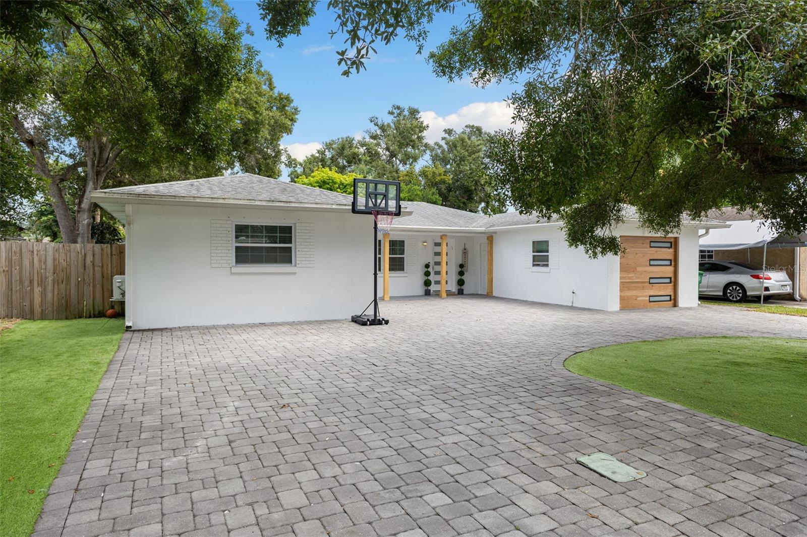 Nestled on a quiet dead-end street in the heart of South Tampa, this single-story residence offers over 2,600 square feet of refined living space within the highly sought-after Plant High School District. Featuring a total of five bedrooms and four bathrooms, the home is situated in an X Flood Zone and has never sustained damage from storms, providing peace of mind in addition to its prime location. A circle driveway welcomes you home, offering both curb appeal and ample parking. From the moment you step inside, you are greeted by an open layout that seamlessly connects the kitchen, living room, and dining. The kitchen serves as the centerpiece of the home, offering a bright, airy space. Three guest bedrooms are thoughtfully arranged: one with its own en-suite bathroom, while the other two share a guest bath. Each bedroom includes a private closet. The primary suite is privately tucked away, complete with its own second living area. The suite also features a spacious bedroom, walk-in closet, additional closet buildouts, and a spa-inspired bathroom. French doors open to a huge screened-in back patio, nearly 1,000 square feet, with a full outdoor kitchen and multiple seating areas. The backyard is fully turfed for easy maintenance and offers ample room for a pool. Completing the property is a detached one-bedroom, one-bathroom ADU (not included in the main square footage), perfect for extended family, guests, or private office use. This South Tampa home offers a smart layout, versatile living spaces, and a true emphasis on indoor-outdoor living - all in one of the city’s most desirable neighborhoods.