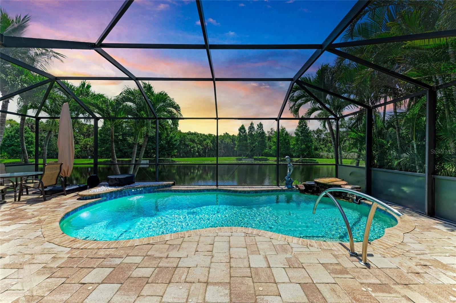 Gorgeous views and beautiful recent upgrades make this model-level residence a must-see home. The idyllic outdoor living space is exceptional with a heated saltwater pool with water features. Nestled against the backdrop of a lush preserve and sparkling lake, this open concept home offers sweeping views and immense privacy. Located in the gated enclave of Woodbrook, residents enjoy a quiet and picturesque neighborhood just minutes from Sarasota's main attractions. This well-built and energy efficient home offers 3 bedrooms + a den with double doors and 2.5 baths, perfect for full time or seasonal residents. Pocketing sliding glass doors seamlessly blend indoor and outdoor living spaces. Steel hurricane shutters provide peace of mind. Recent upgrades include a new pool heater, freshly painted interior and exterior, designer lighting, and fabulous quartz counters. Timeless tile flooring, elegant crown molding and trim, classic plantation shutters and a stacked stone feature wall are details you’ll appreciate. Tall tray ceilings lend an airy ambiance, and soft sunlight gently carries through the main living areas. This quality-built home offers a beautiful and functional kitchen with rich wood cabinetry, gleaming quartz countertops, stone backsplash, a walk-in pantry, and GE Profile stainless steel appliances. The owner’s retreat features handsome wood flooring, spectacular views, two walk-in closets with custom built-ins, and an en-suite bath with dual vanity and frameless glass shower. The split floor plan offers plenty of space for gathering and privacy. The private den offers flexible space for a home office, playroom, or media. Private showings available for qualified buyers. Residents of Woodbrook enjoy a charming tree-lined community perfect for walking, jogging, or bicycling. Amenities include a resort pool/spa, grill area, playground, and park.