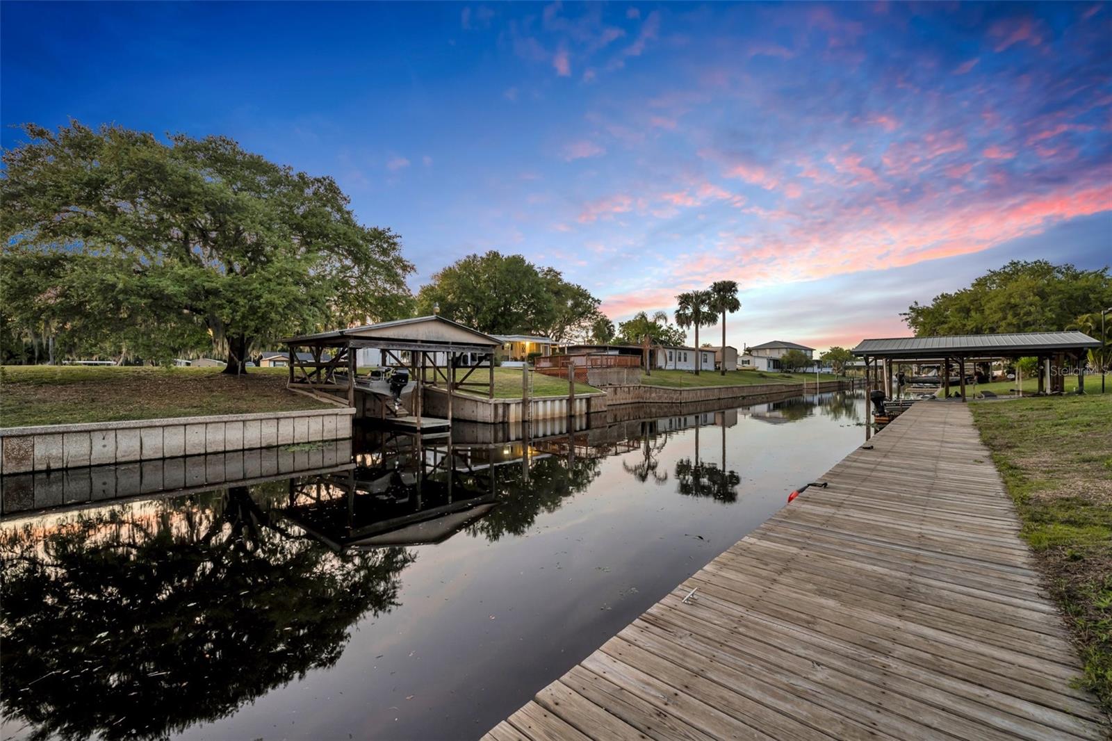 Cast Off from the City and into Your Waterfront Escape! Fuel up the boat, gather the family, and let the river set the pace—your dream life starts at 2072 Starboard Drive. This spectacular custom-built estate sits on a private deep-water canal with direct access to the legendary St. Johns River, offering the perfect balance of luxury, adventure, and relaxation. Built entirely of solid concrete, this home is as resilient as it is breathtaking. Step inside to soaring ceilings, 8-foot doors, and warm, 100+ year-old reclaimed barn wood floors that instantly make you feel at home. The chef’s kitchen—complete with Wolf and Sub-Zero appliances—flows seamlessly into expansive living and dining areas, perfect for family gatherings, lively weekends, or quiet evenings by the water. The first-floor primary suite is a private sanctuary, boasting river views, a spa-worthy marble ensuite, and a walk-in closet that doubles as a safe room. Upstairs, three generously sized bedrooms, a full bath, and a spacious loft create the ideal setup for kids, guests, or a game/media lounge. Outdoors, the covered patio with summer kitchen is made for cookouts and celebrations, while the new seawall and boardwalk (2022) put boating, fishing, and waterfront lounging right at your doorstep. A whole-house generator, smart wiring, comprehensive security, and a newly finished epoxy garage floor (2024) add peace of mind. Whether it’s your full-time residence or weekend getaway, this riverfront retreat delivers the boating lifestyle, family memories, and serene escape you’ve been dreaming of—just far enough from the city to feel worlds away. Welcome Home!!
