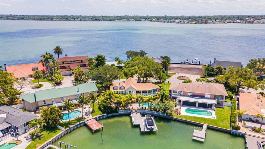 Your dream lifestyle, boating and beach days in Florida, awaits! Welcome to Belleair Beach, one of the most elite beaches of Florida with private parking access for residents only to beautiful sandy beaches. Drive down Belle Isle, the most coveted street in Belleair Beach, palm trees and gorgeous homes dot the road. Arriving at your home the wide driveway greets you to lead to your oversized garage. This fully renovated five bedroom, three and a half bath pool home boasts elegant traditional architecture surrounded by lush and manicured landscaping. Inside the expansive entryway you're immediately welcomed with water views. Hurricane rated sliding glass doors and windows throughout provide sparkling water views from almost every room! No expense was spared in the renovation of your new home including hand-scraped hickory hardwood floors, high ceilings, crown molding, and wired sound system. Host your guests in style in the traditional dining area complete with custom RH Crystal chandelier or expansive living room. Elegance and convenience are on hand as you create a culinary delight in the chef’s kitchen! It boasts custom cabinetry, dual sinks, gas stove, under counter beverage center, granite countertops and custom breakfast nook. The indoor entertainment space and lanai connect by sliding glass doors for indoor/outdoor enjoyment. The vast screened lanai is made for entertaining with a built-in natural gas grill-island, granite counters plus it’s wired for audio! The split floor plan allows for privacy with the owners’ suite tucked into the right side of the home. Wake up in this hidden oasis set behind expansive bougainvillea adjacent to the private sliding glass doors. This luxurious owners’ suite has a walk-in custom closet and an elegant bathroom with walk in shower, two vanities, custom cabinets and designer tile throughout. On the opposing side of the living space is a private en-suite with bath, perfect for visiting guests, live-in au pair or office. Ascend to the second floor to discover the additional bedrooms and full bath. Each bedroom is graced with magnificent views of the water and ample closet space. Want to admire the sunset from another vantage point, step out onto the sweeping second story balcony. Back down on the ground level choose from an array of outdoor options! You can watch the dolphins from the saltwater pool or watch the sunset while under the romantic Bougainvillea adorned gazebo. Your opulent refuge has nearly 80 feet of water frontage and is encircled by flourishing greenery creating privacy. Adventure awaits as you walk down the extra large Trex dock! Built in 2018, it is fitted with power, water and a 10,000 lb. custom platform lift. Paddle your kayak along the channel or take your boat out to the Gulf with easy access to the open water for a thrilling boat day! If beaches are what you desire, a quick golf cart trip loaded up with accessories is a grand idea. Or you can walk or ride your bike to any of the multiple private Belleair Beach access spots then rinse off in the hot water outdoor shower before retiring for the evening! Updates include:electrical, plumbing, drywall, roof, hurricane rated impact windows, 2 zone HVAC units, Tankless Hot Water Heater (2015), dock, lift, water softener (2018) and one zone of HVAC and NEST (2021). Enjoy vacation living full-time in this maintenance free fully remodelled home. Make your appointment to see it today to make your Florida dream life your own tomorrow!