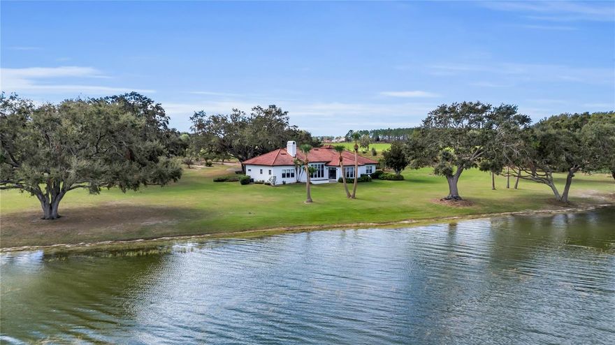 Discover your own piece of paradise in Central Florida with this breathtaking Mediterranean-style home on the shores of 4,000 ACRE
LAKE YALE. Nestled at the end of a PRIVATE, oak-studded 10-acre Agricultural grove, this custom-built oasis combines SIMPLE
LUXURY with serene, NATURAL BEAUTY. As you approach, FEEL A WORLD AWAY, embraced by the tranquility and privacy only
an EXPANSIVE ESTATE like this can offer. Step inside to experience PANORAMIC, unobstructed VIEWS of over 400 of PRISTINE
LAKEFRONT, visible from nearly every room. This home’s thoughtful design features a grand 14-foot foyer and spacious 12-foot
ceilings to enhance the elegance of its waterfront setting, welcoming you into a space where SIMPLICITY MEETS LUXURY, creating
a peaceful, almost otherworldly retreat. Perfectly situated between the charming town of Mount Dora and the bustling community of
The Villages, this home is convenient to both the vibrant attractions of Disney and Universal and the natural beauty of Florida's
beaches and springs. If you dream of privacy, luxury, and an unparalleled lakefront lifestyle, this rare Florida property awaits you.