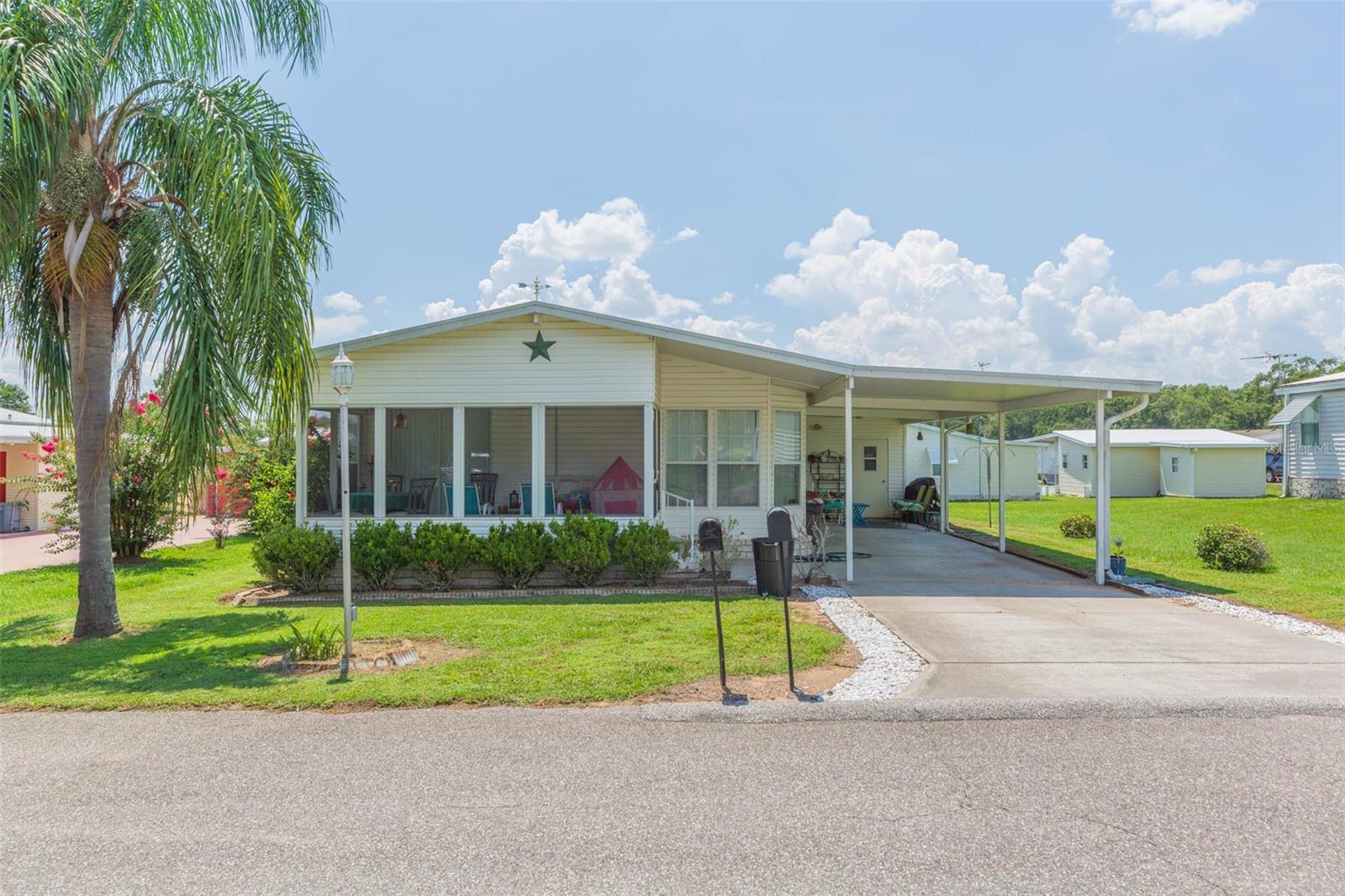 A PLATINUM home for your GOLDEN YEARS... Well maintained 2br/2ba HOMES OF MERIT doublewide mobile home in a quiet, gated 55+ active community. Lot is included. No lot rent, you own the lot Many extras are included with this home including a 12' x 21' workshop, and an 8' x 16' screen enclosed lanai that is a perfect space to enjoy the mild Florida climate. Open floor plan features an island kitchen with island cooktop and built in wall oven plus island seating area making it great for entertaining friends. Energy efficient features include new metal roof installed 2020, a tankless water heater and double pane windows. The spacious master bath features a large garden tub with separate walk in shower. Practice your favorite craft or hobby in the workshop which includes a window air conditioner. Other features included are gutters with downspouts and a water softener system. The gated community is conveniently located minutes from Dade City, Zephyrhills, or Lakeland. Community amenities include clubhouse, shuffleboard, and heated pool. Community also features private sewer, private water, and private streets. Monthly HOA fee INCLUDES WATER, SEWER, AND TRASH SERVICE. Only 53 miles to Orlando attractions and 48 miles to Tampa International airport.