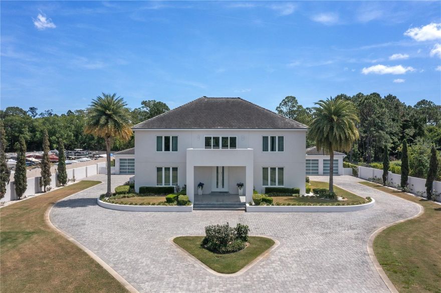 On a sprawling one-acre lot along Millionaires Row in Orlando’s Dr. Phillips community, this custom, gated estate exemplifies luxury living at its finest. Luxury extends to every corner of this home, from the Porcelanosa large profile flooring on the first floor to the Emil Italian wood-look porcelain on the second floor. The 20-foot ceiling adds a sense of airiness and spaciousness to the first floor. Entertain with ease throughout with open concept living spaces, highlighted by the customizable home lighting control system, setting the ideal ambiance for any occasion. Step into culinary paradise with your exceptional kitchen, adorned with top-of-the-line Miele, Wolf and Sub-Zero appliances that elevate meal prep to unparalleled heights. Brazilian Blue Bahia granite countertops grace the expansive 17-foot kitchen island, offering ample space for culinary creativity and entertaining guests. The Blum Aventos motion lift cabinetry with Parapan solid acrylic finishes adds a touch of modern sophistication while maximizing storage efficiency. Efficiency meets innovation with the inclusion of a Miele dishwasher, ice maker and refrigerator storage drawers. This sprawling home offers space for every activity. Work quietly from the designated home office or host meetings and meals in the formal dining room. The sprawling living and family rooms are accessible from the kitchen and provide seamless indoor-outdoor living with collapsible doors that create a fluid transition between spaces. The alfresco stainless barbecue grill and built-in summer kitchen make hosting gatherings a breeze. Convenience meets comfort with the outdoor shower, and pool-changing and laundry rooms. For sports enthusiasts, a basketball court waits for friendly competition. The impressive first-floor primary suite includes 10-foot ceilings, patio access, incredible walk-in closet and spa-like bath adorned with Marmara Blanco marble from Spain. Ascend the stainless and marble floating stairs to find a junior bedroom suite with den, additional en suite, two more well-appointed bedrooms, an open-air seating area and loft that serves as a media room. Smart home features include a video monitor displaying multiple cameras and a surveillance system, as well as a Tumo Xcel automatic drapery system for effortless control of natural light and high-end water purification system. Outside are dual two-car garages, adorned with 9-foot frosted, insulated glass doors adding a touch of elegance and providing ample natural light while maintaining privacy. These garages cater to the needs of car collectors and enthusiasts alike. The left garage offers a dedicated workshop space, providing the ideal environment for tinkering and fine-tuning your prized possessions. No detail has been overlooked, with custom cabinetry and a refrigerator enhancing functionality and style. Whether you're admiring your collection, working on restoration projects, or simply enjoying the serenity of your automotive sanctuary, these garages epitomize luxury and practicality, a car collector's necessity. Security and privacy are paramount to the homeowners, with a concrete security wall, gated entry system with intercom and a governor's driveway, you’ll appreciate an extra layer of exclusivity. This is more than just a home, it's a sanctuary of style, sophistication and unparalleled quality, crafted to exceed even the most discerning buyer's expectations.