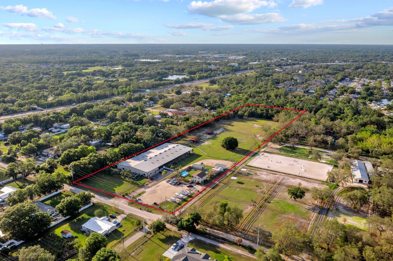 This 10.07-acre prime property offers an opportunity for Mixed-use development. Perfect for a Dog or Horse business. Currently, it is Tampa Bay's Premier Pet Boarding facility offering daycare, training, and walking services for Dogs. There are approximately 328 feet of frontage along Gardner Rd in the Citrus Point Area, near Veterans Hwy, Citrus Park Mall, The Upper Tampa Bay Trail, the sought-after Westchase Area, medical facilities, multiple restaurants, and more.
Building 1. State of the Art Florida Steel Metal Frame *Built-in 2003 *Arena 200ft x 125ft * Height 18ft *Ceiling insulated *Lighting no shadowing, no heat *ample electric power available *Property is on septic and well with a large dry hydrant 20,000-gallon septic tank
*In the Open Air Arena, the ground area is a mixture of clay and dirt (a perfect surface for dog agility, flyball, etc., and plenty of room to add more to accommodate a horse business. *Inside office/animal area is 50ft x 125ft fully air conditioned *concrete floors with rubber
covering *2 air conditioners *Office work area with back storage cabinets, 3 desks, office cabinets, office file cabinets, a glass display case, refrigerator, 2 water heaters, and a restroom with toilet and sink *garage shed behind the boarding and daycare area. *Hurricane shutters included and 30 DVR security cameras.
Building 2. Home *2 stories *2 studios SQ FT HEATED 1520 SQ FT TOTAL 1740*BUILT IN 1986*Bottom of home cement Top of home wood frame and vinyl *UPSTAIRS unit has a refrigerator, stove, dishwasher, washer, dryer, microwave, ceiling fan, shower, toilet, sink, and a separate bedroom. *DOWNSTAIRS unit has a refrigerator, microwave, AC, water heater, washer, dryer, shower, toilet, sink, *hurricane shutters for Home. There is an above-ground pool with pump (designed for dogs). 2 dog kennels 6x6 each, chain-link with a roof and a wood fence around the home area. Property is on well and septic.
The Front entrance of the property is an asphalt driveway and 7 parking spaces in front of the office/drop-off area. On the right is a shell parking lot. The Front field, on your left, is fenced in for your dog or horse safety.
On the Property:*4 sheds including a 3-port garage shed *Regular sheds *an open shed* 2-Carports with storage area for any use *9 RV hookups with power (1-60 amp 8-30amp).
Backfield: *A safe sheep night enclosure (a round herding-training pen) *A feed shed *4-horse stall with large run-out paddocks *2 horse grazing fields (500x300) & (60x40) *storage for hay and food.
Back of property: A huge filtration system is in a large building. The "Well Mate" for entire property. There are 2 septic tanks 1 for the house and 1 for the large building. *A back gate to the very peaceful rocky creek for relaxing and enjoying the Cypress Trees, birds, and more nature. There is a wonderful trail for walking. *Retention pond *picturesque Oak Tree. BEAUTIFUL SUNSETS.
Buyers need to conduct thorough due diligence to ensure that the property meets your expectations and requirements. Buyer is responsible for verifying all information contained in this listing.