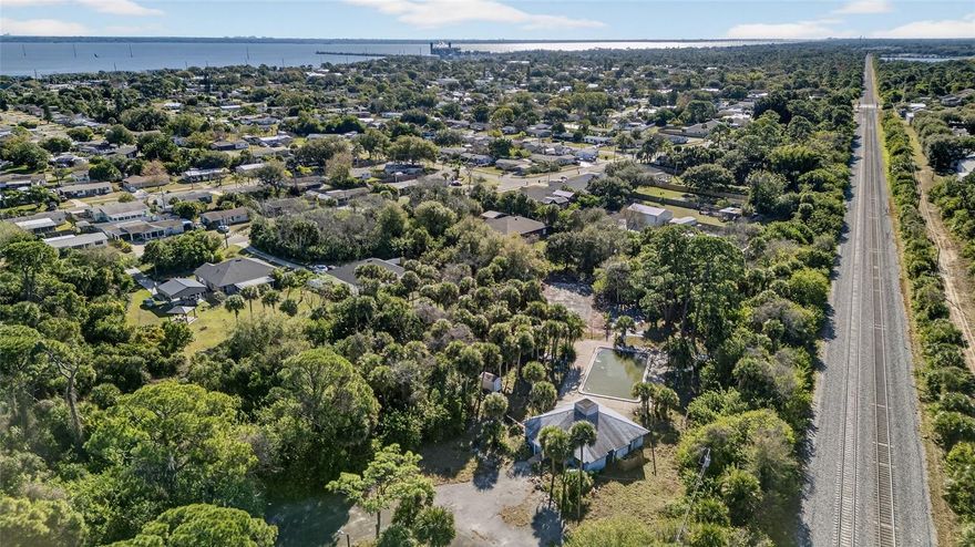 Rare opportunity to acquire four parcels totaling approximately 5.83 acres in desirable Port St. John, Brevard County. The offering includes three vacant lots measuring approximately 0.66 acres, 0.66 acres, and 0.09 acres, plus a 4.42-acre parcel featuring a former recreation hall and multiple outdoor amenities. The existing ~1,697 sq ft stucco building (built 1980, metal roof) is a flexible, multi-use structure with potential for conversion to a residence, office, or business use (buyer to verify zoning and permitted uses). Property features include a paved circular driveway, tennis court, shuffleboard area, pool (currently drained and in need of repair), outdoor brick grill, outdoor lighting, stone paving, and fencing. All parcels are adorned with beautiful mature pine trees, offering privacy and a natural Florida setting. No HOA (association dissolved in 2025). Properties and improvements are being sold AS-IS.