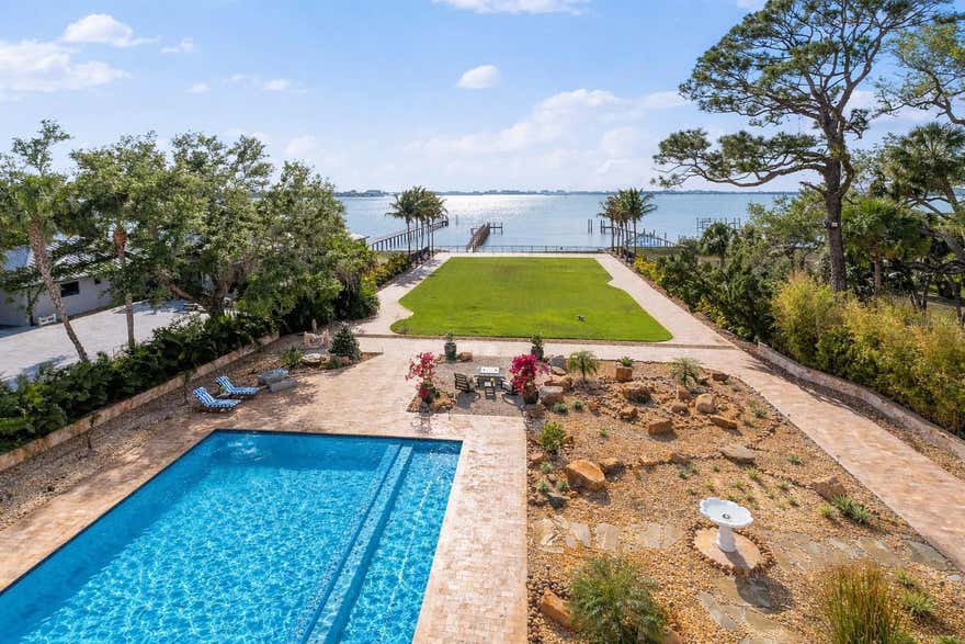 Palazzo Sul Mare is a rare waterfront estate in St. Petersburg’s coveted Jungle Prada neighborhood, offering over 19,000 square feet under roof and more than 10,000 square feet of interior living space on over 1.5 acres along the Intracoastal Waterway. Built in 2020, this residence blends modern construction with timeless European-inspired design—an offering rarely found in this market.
A grand motor court and porte-cochère create a secure, estate-style arrival. An imported limestone exterior, along with wrought iron detailing, a distinctive blue dome, fountain, marble statuary, and mature oak trees, establishes a timeless setting surrounded by tropical landscaping and the neighborhood’s iconic peacocks. Inside, a dramatic domed rotunda crowned by a crystal chandelier anchors the home, featuring inlaid marble flooring and dual sweeping marble staircases. The layout captures water views throughout, with a gallery-style corridor ideal for art, a grand piano, or entertaining. Marble archways and columns, gold and iron balustrades, and detailed ceilings create a striking architectural presence, while illuminated art niches enhance the home’s scale and design continuity.
Custom millwork, fresco-style ceilings, and imported marble flooring span all three levels. The kitchen features a full suite of Thermador appliances, including a 60-inch gas range, integrated refrigeration, and built-in coffee system, along with quartzite surfaces and an illuminated onyx island. A custom Chihuly-style installation of hand-blown glass creates a focal point above, while the curved glass dining area frames panoramic water and pool views with space for large-scale entertaining.
The residence includes multiple bedroom suites, several exceeding 1,000 square feet, many with spa baths, expansive closets, and private lanais with water or garden views. The main-level primary suite offers a marble bath with Phylrich fixtures, sauna, soaking tub, multiple vanities, and panoramic water views beneath a custom fresco ceiling.
A private office on the main level features paneled walls, built-ins, an ornate stone fireplace, and balcony access. The upper level includes a club-style lounge with a quartzite waterfall bar and sunset views. The home spans three levels with elevator access and marble staircases, with laundry rooms on multiple levels.
Outdoor living includes a zero-entry pool, lap pool, 2 spas (hot and possible cold), 5 terraces, courtyards, fire pit, private sandy beach, citrus trees, and a wide rear lawn. The grounds offer flexibility for a guest house or ADU, sport court, cabana, or greenhouse. The private dock includes a 10,000-lb lift, additional lifts for personal watercraft, a wet slip for a yacht, and direct Gulf access.
Built for longevity with reinforced pier-and-beam construction on pilings, impact-rated windows and doors, and a stone exterior. Designed with engineered elevation, the residence features elevated living areas (approx. 7.7’ first level and 20’+ upper levels), with no reported water intrusion. Smart home technology, full security camera coverage, solar power, saving thousands per month in electricity, 4 HVAC systems (2023) with 10-year warranties, and 2 whole-house generators for efficiency and reliability.
Garage capacity for approximately 6 vehicles includes additional space for a workshop, recreation, or gym with over 5,000 square feet of lower-level space. A rare combination of scale, craftsmanship, and waterfront presence.